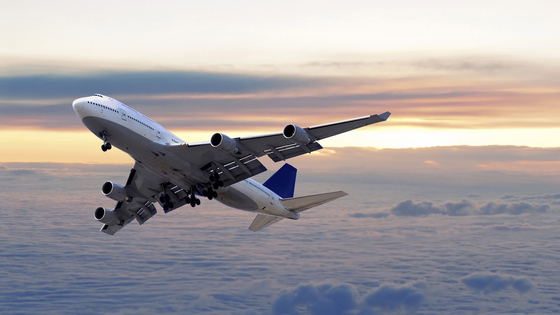 Airplane flying above clouds at sunset HD Wallpaper