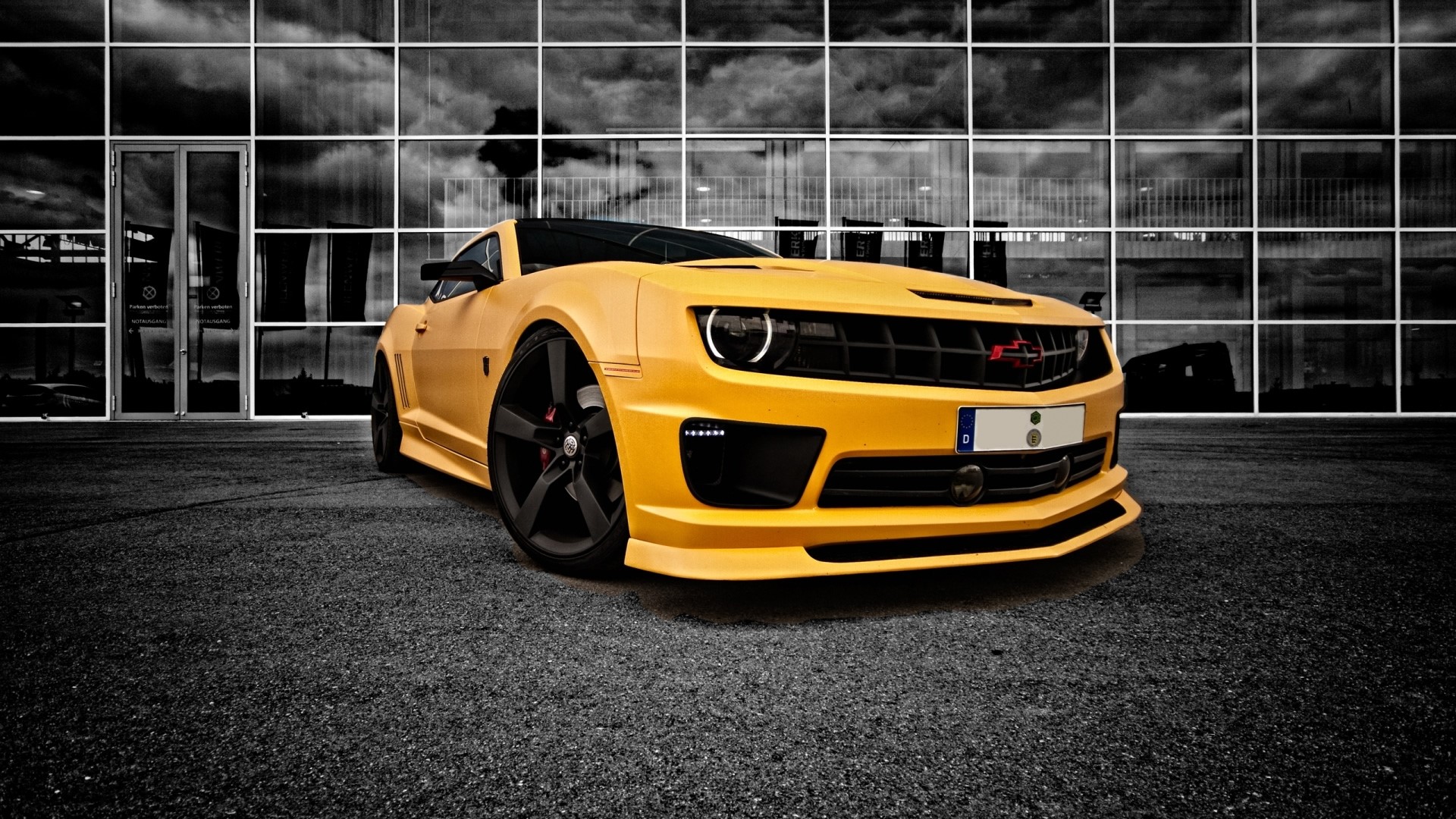 Yellow Chevrolet Camaro parked in front of a modern building HD Wallpaper
