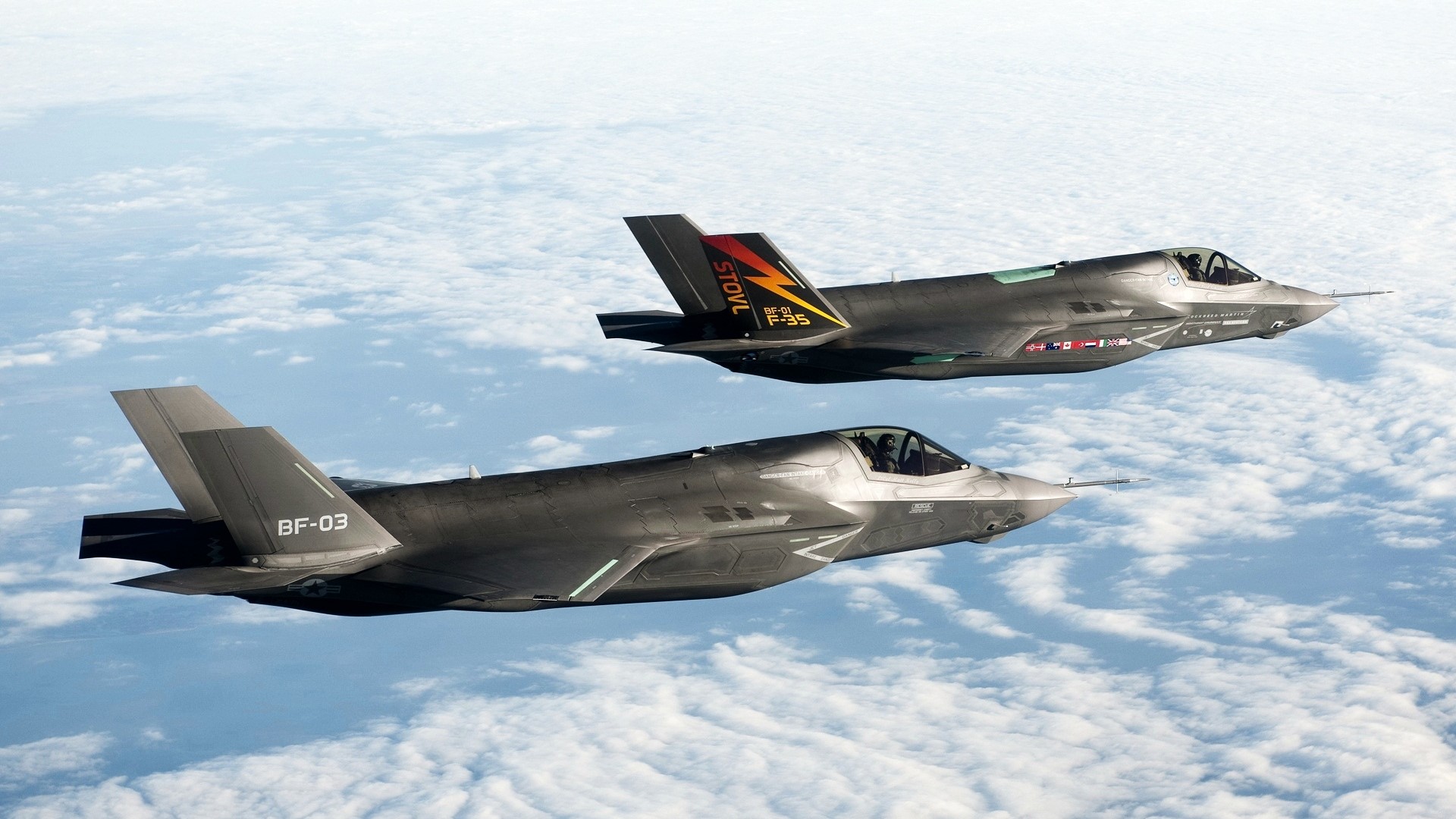 Two F-35 fighter jets flying over clouds HD Wallpaper