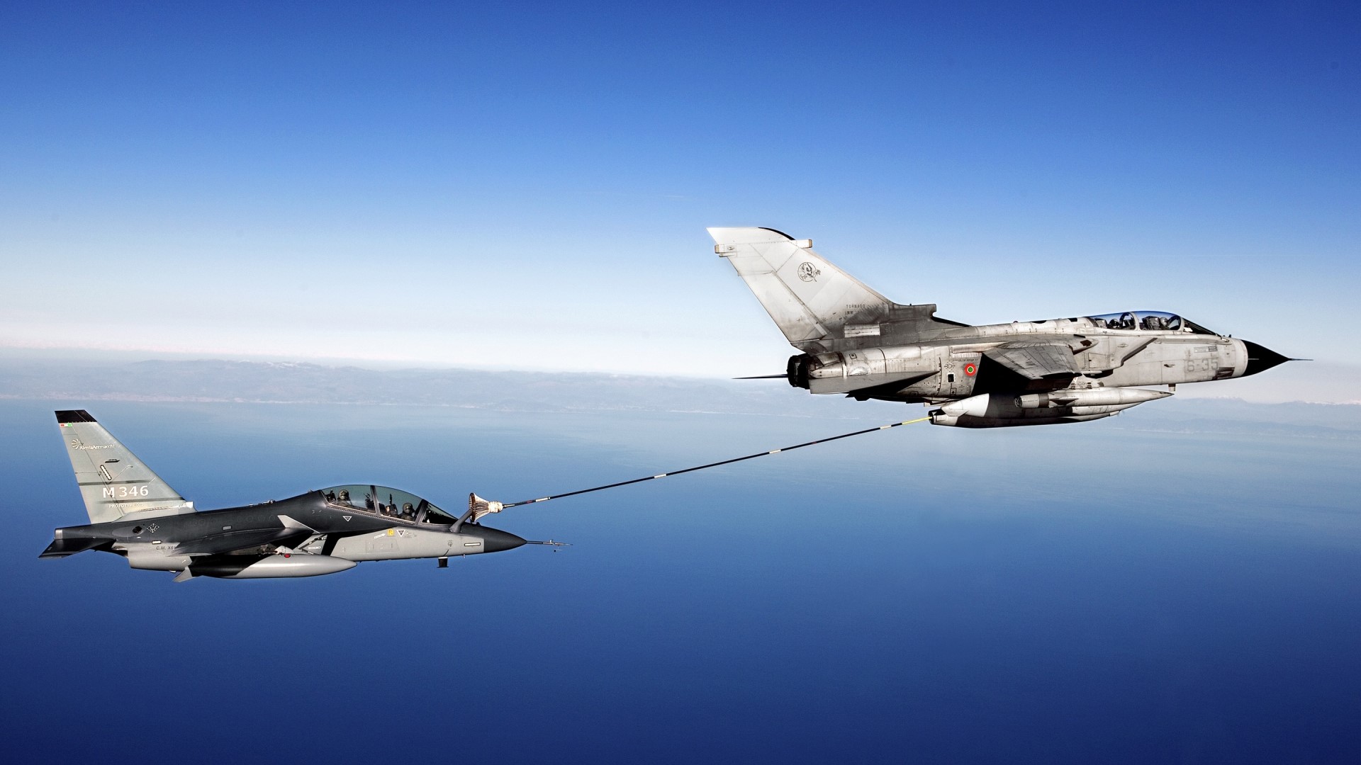 Fighter jets performing air-to-air refueling over the ocean HD Wallpaper
