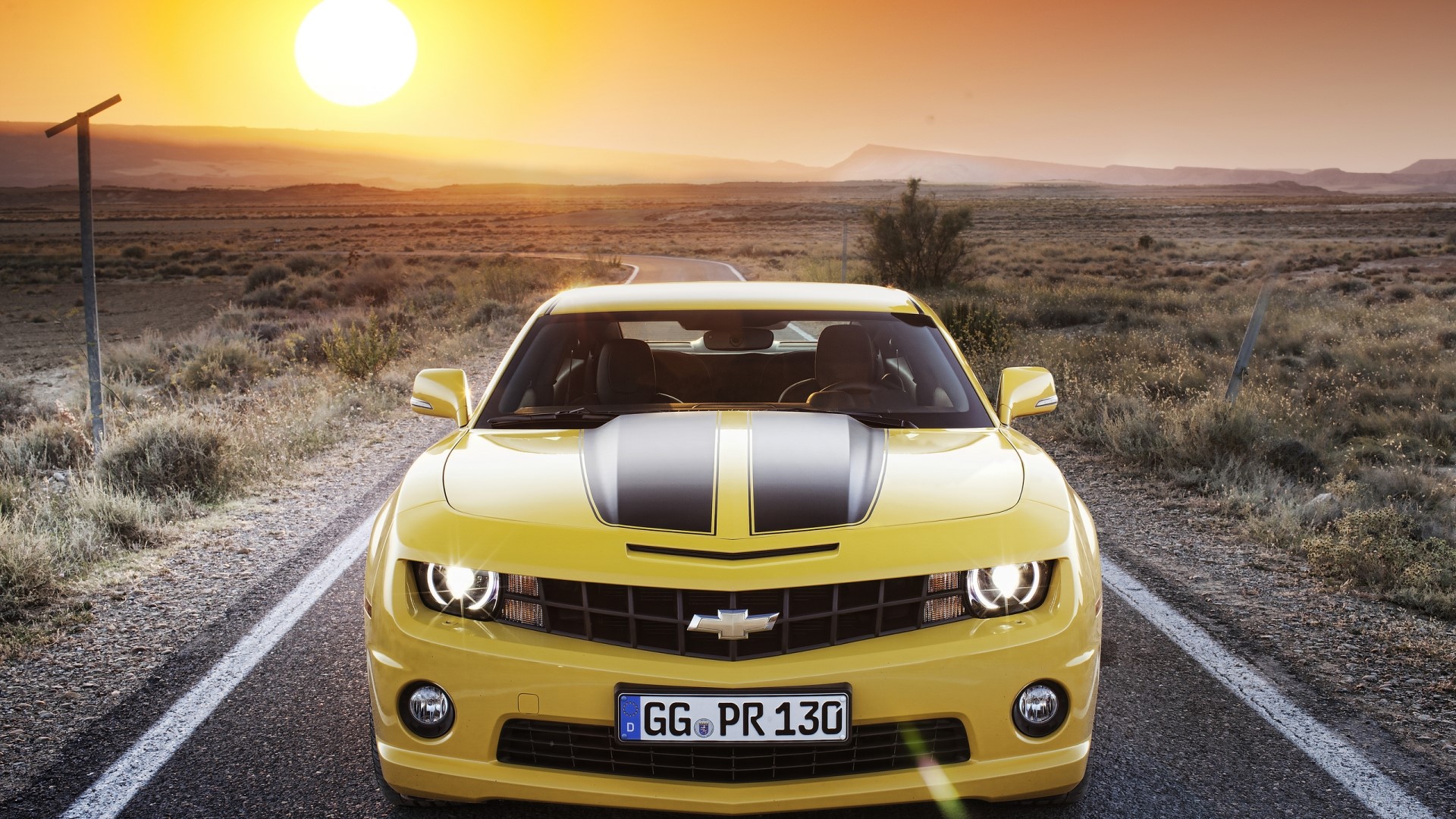 Yellow Chevrolet Camaro on a Desert Road at Sunset HD Wallpaper