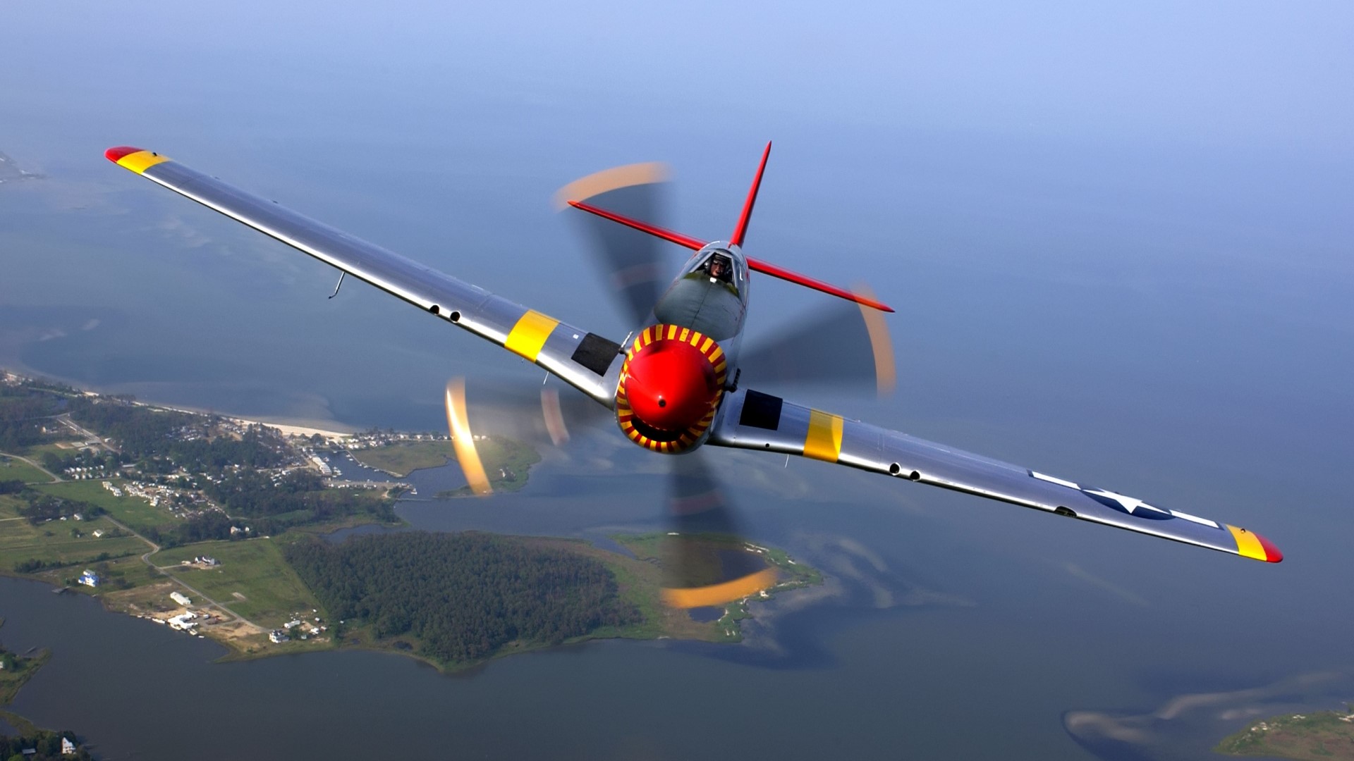 P-51 Mustang aircraft flying over land and water HD Wallpaper