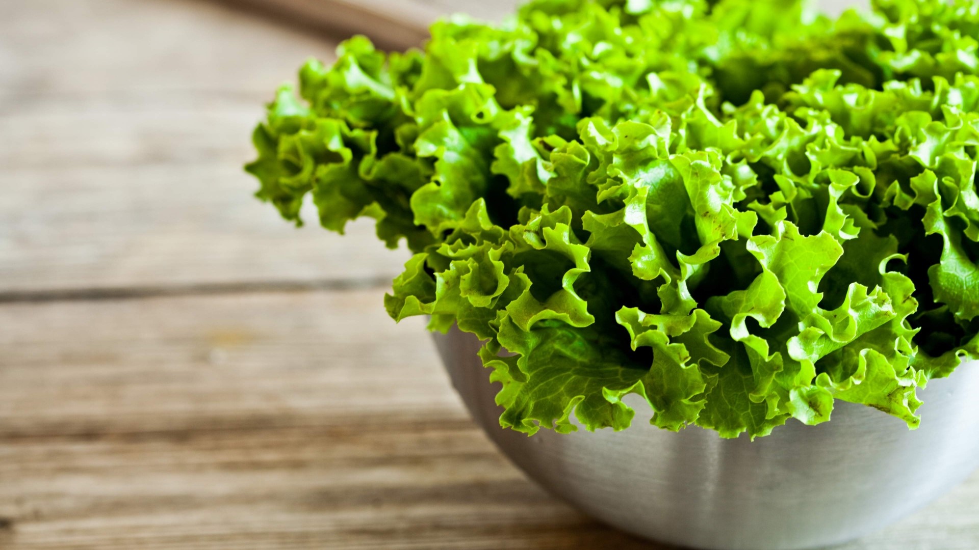 Bowl of fresh green lettuce on a wooden table HD Wallpaper