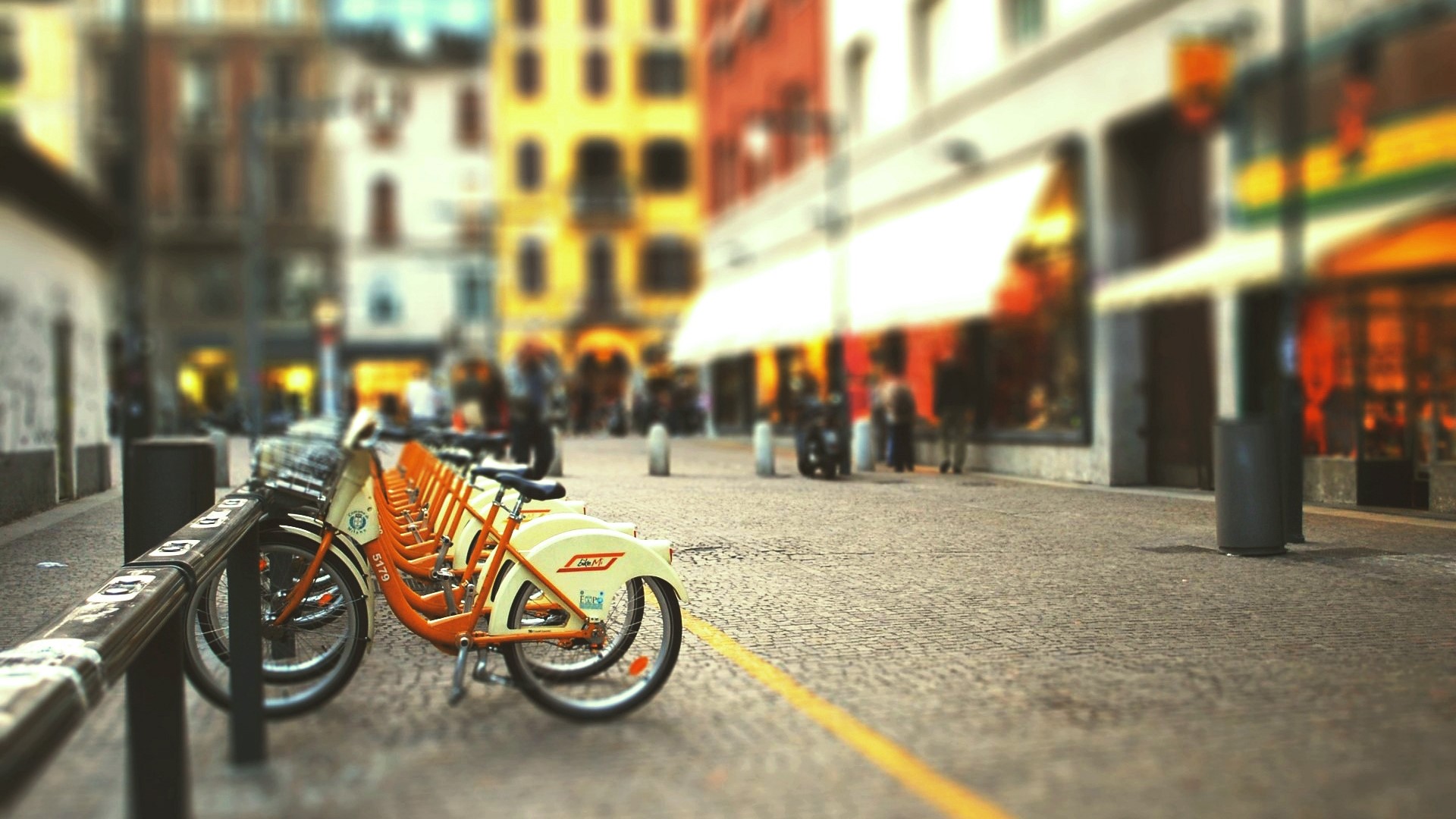 Street bicycles parked on a cobblestone street HD Wallpaper