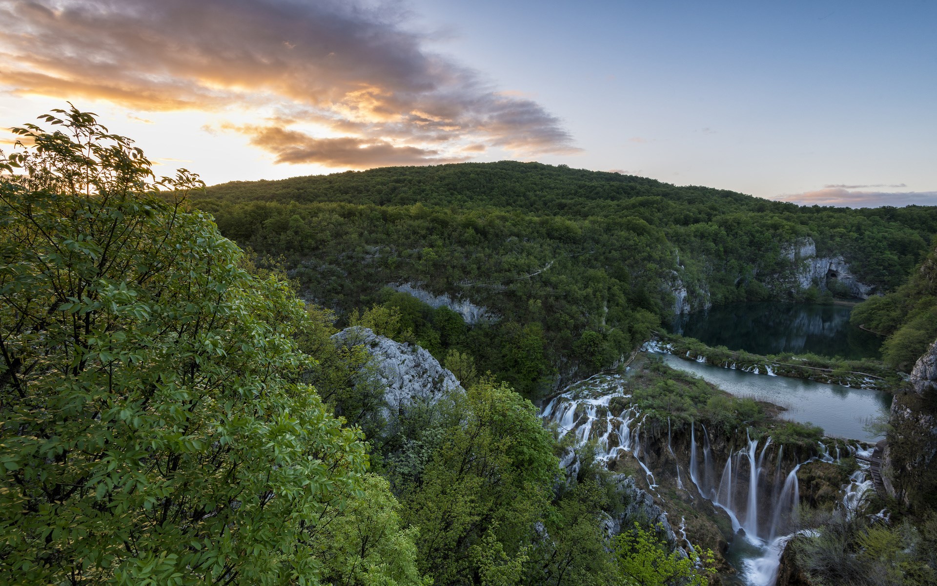 Waterfalls and lush green forest at sunset HD Wallpaper