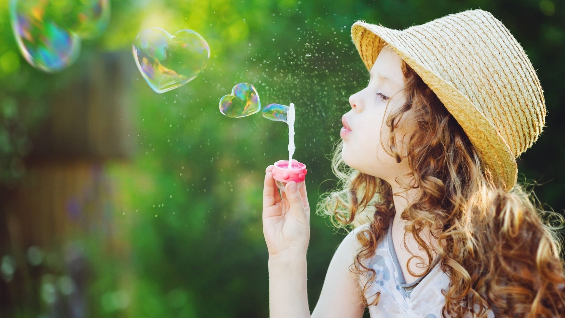Girl blowing heart-shaped bubbles HD Wallpaper