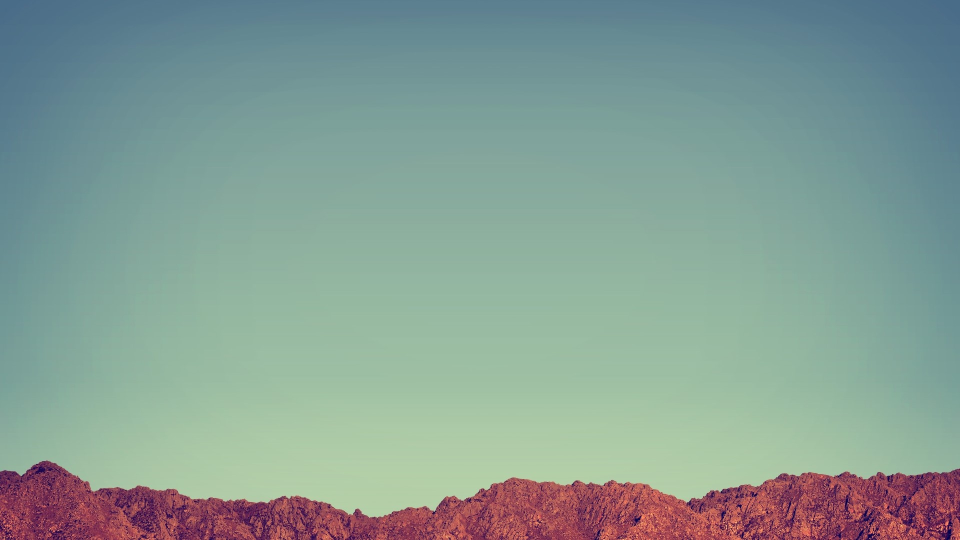 Red Desert Mountains Under a Clear Sky HD Wallpaper