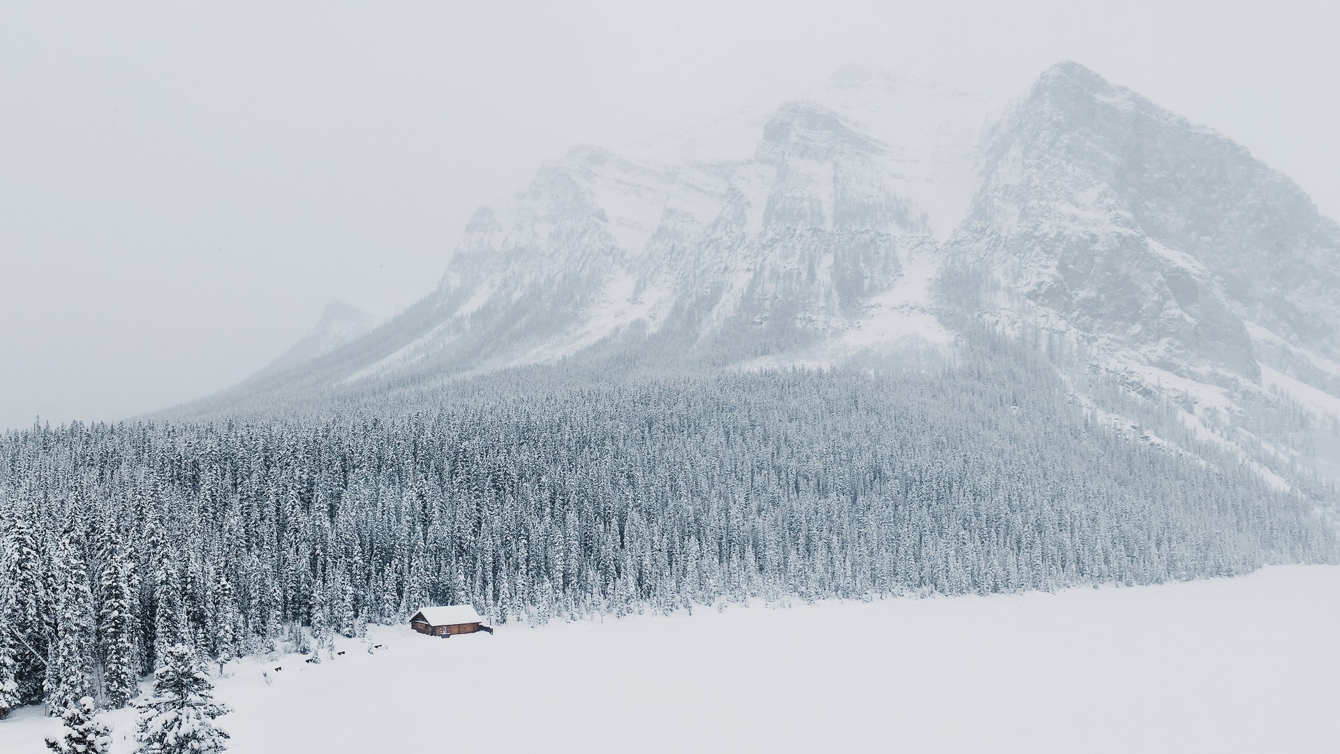 Winter mountain scene with forest and cabin HD Wallpaper