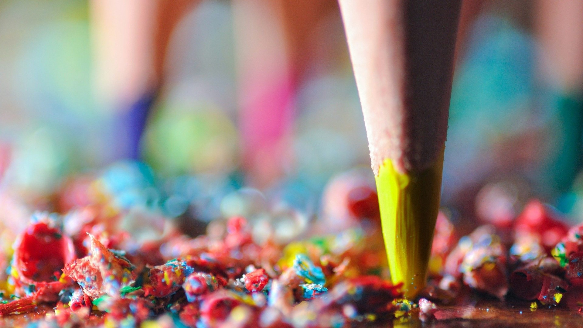 Close-up of a yellow pencil tip with colorful shavings HD Wallpaper