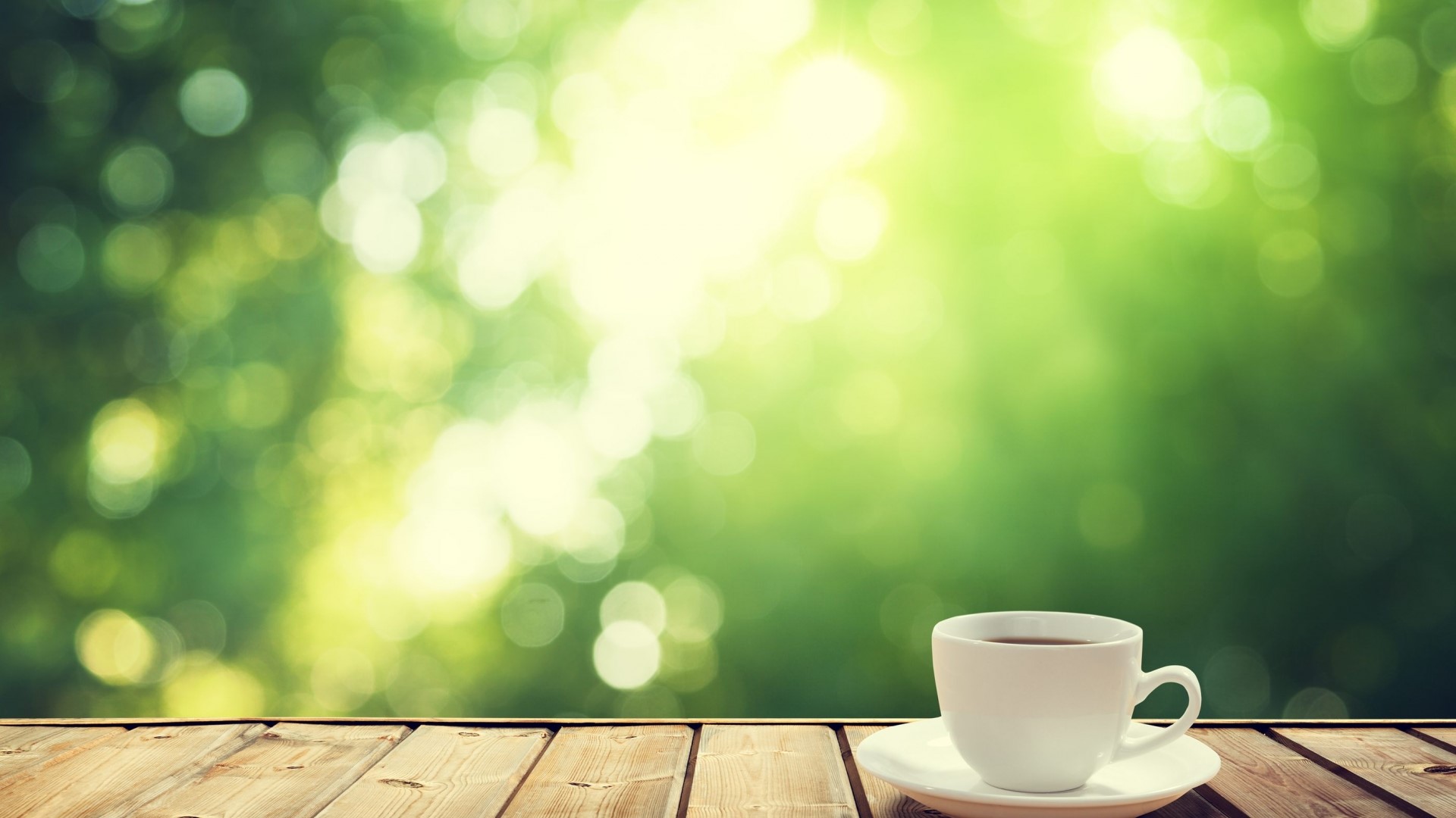 Coffee cup on a wooden table with green bokeh background HD Wallpaper