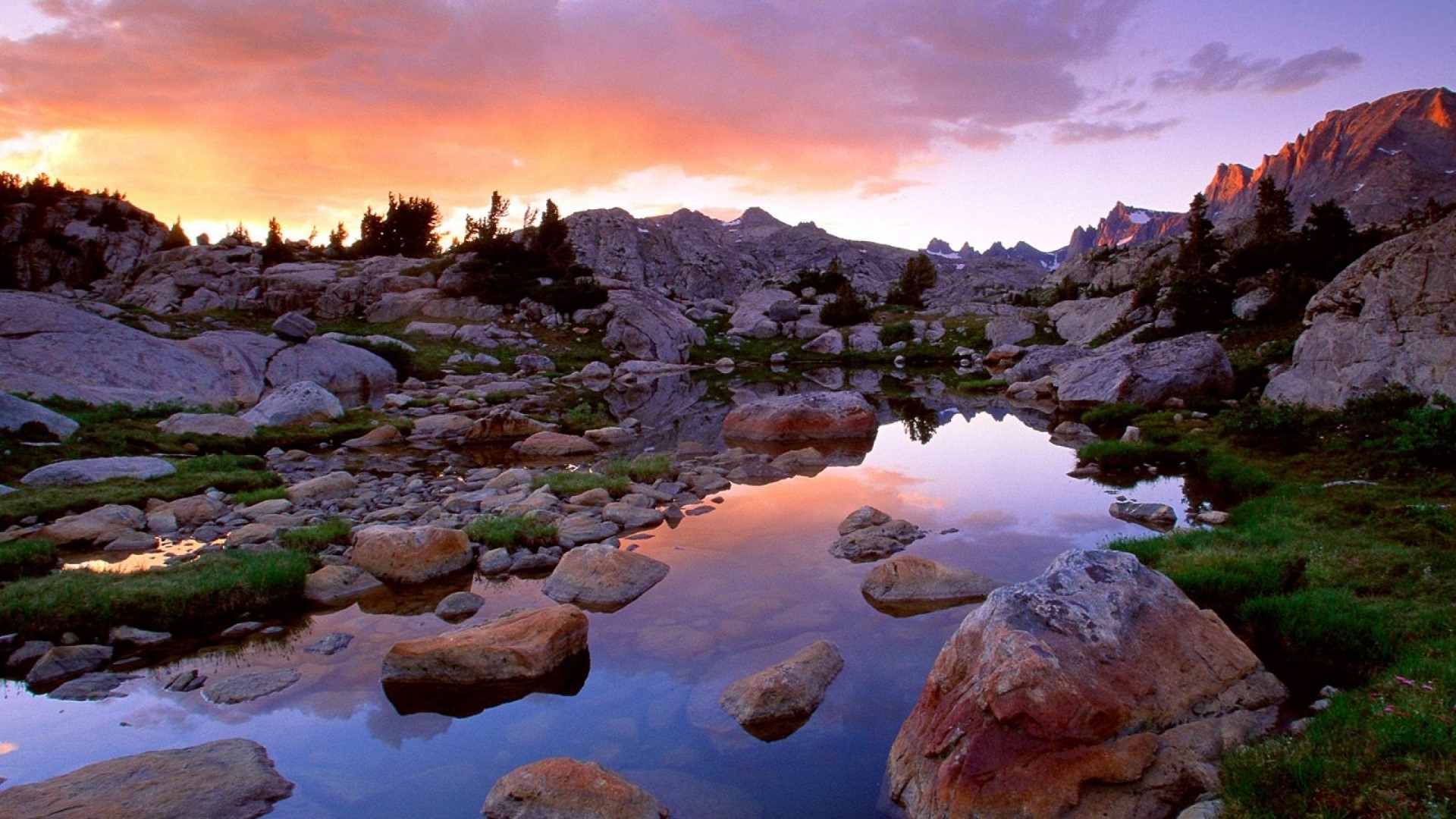 Mountain lake at sunset with rocky shore HD Wallpaper