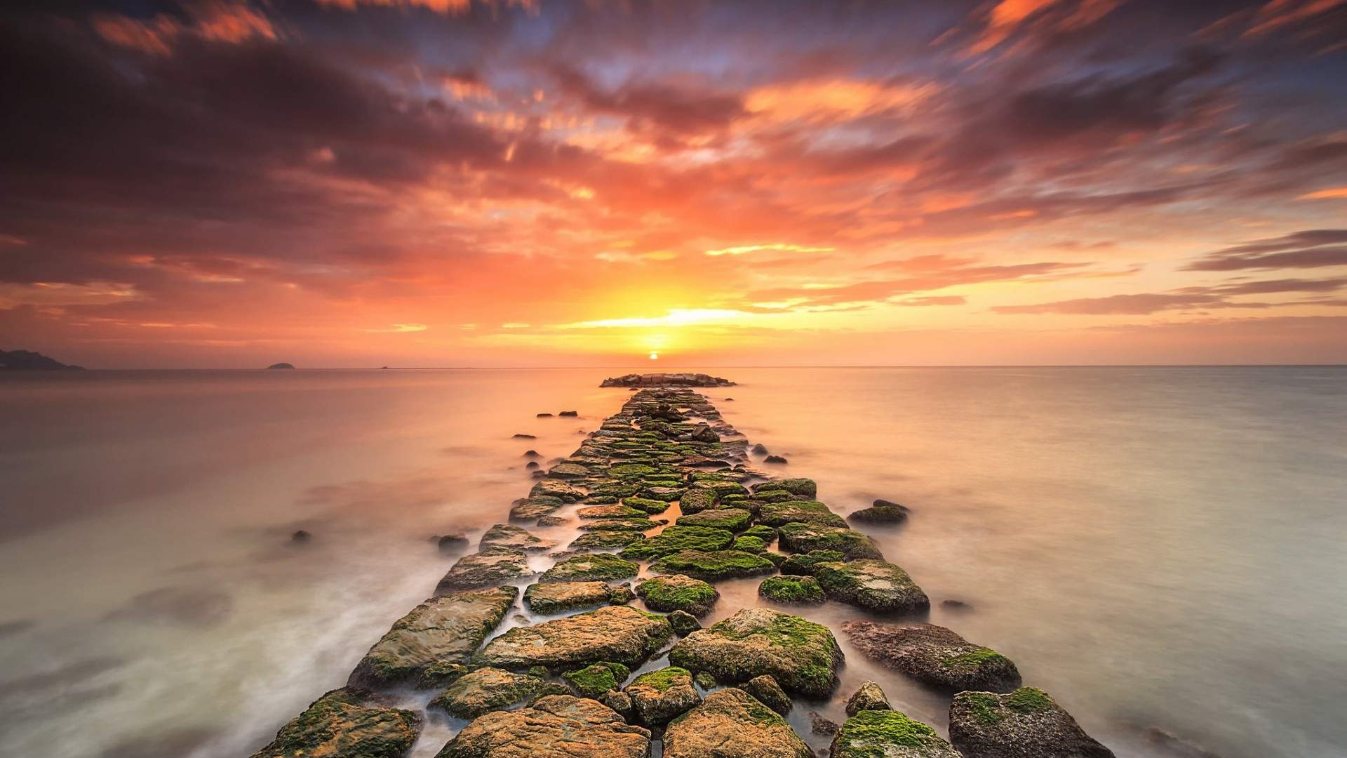 Sunset over the sea with a stone path HD Wallpaper