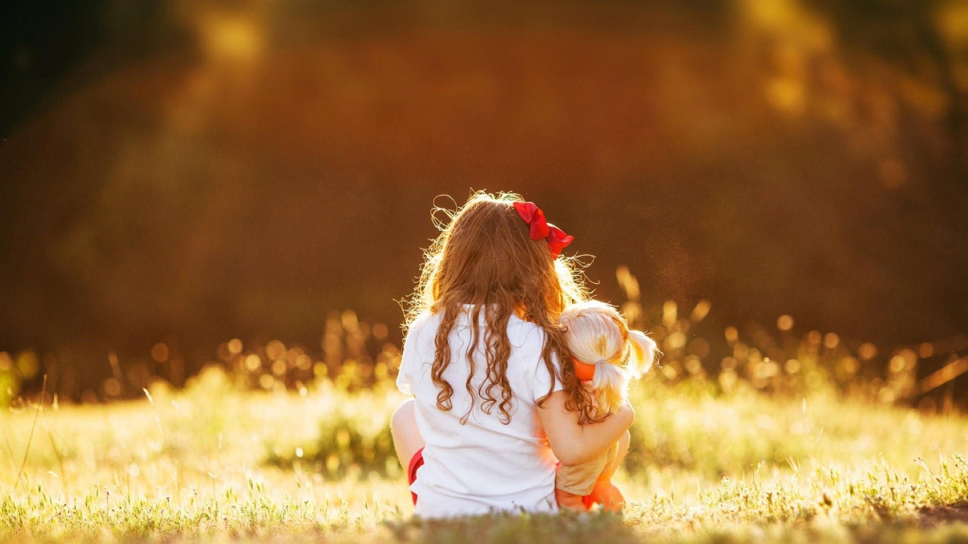 Girl with a doll in a field at sunset HD Wallpaper