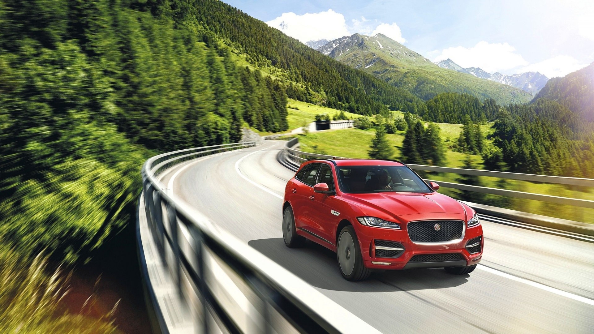 Red Jaguar F Pace driving on mountain road HD Wallpaper