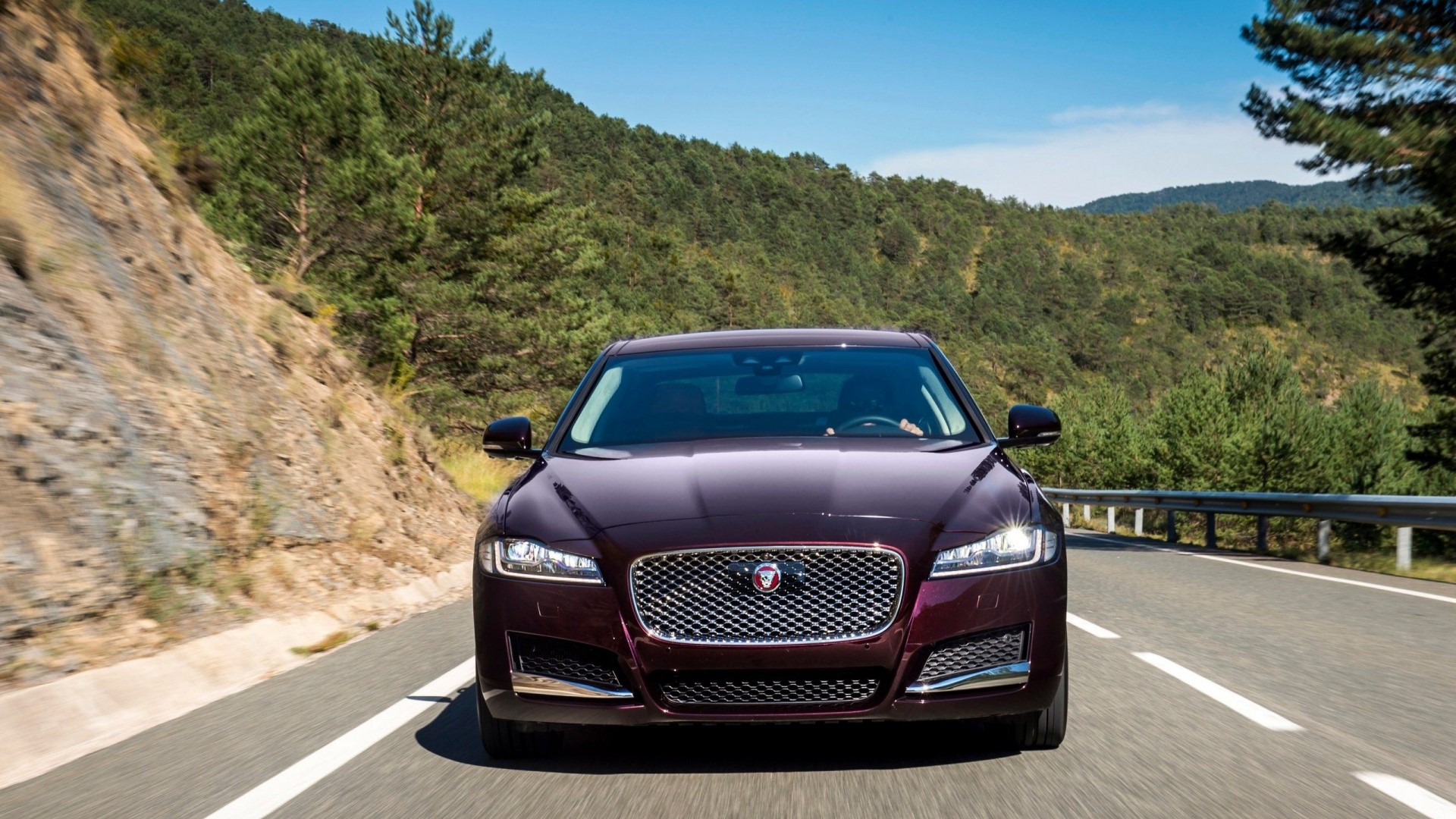 Jaguar XF driving on a mountain road HD Wallpaper