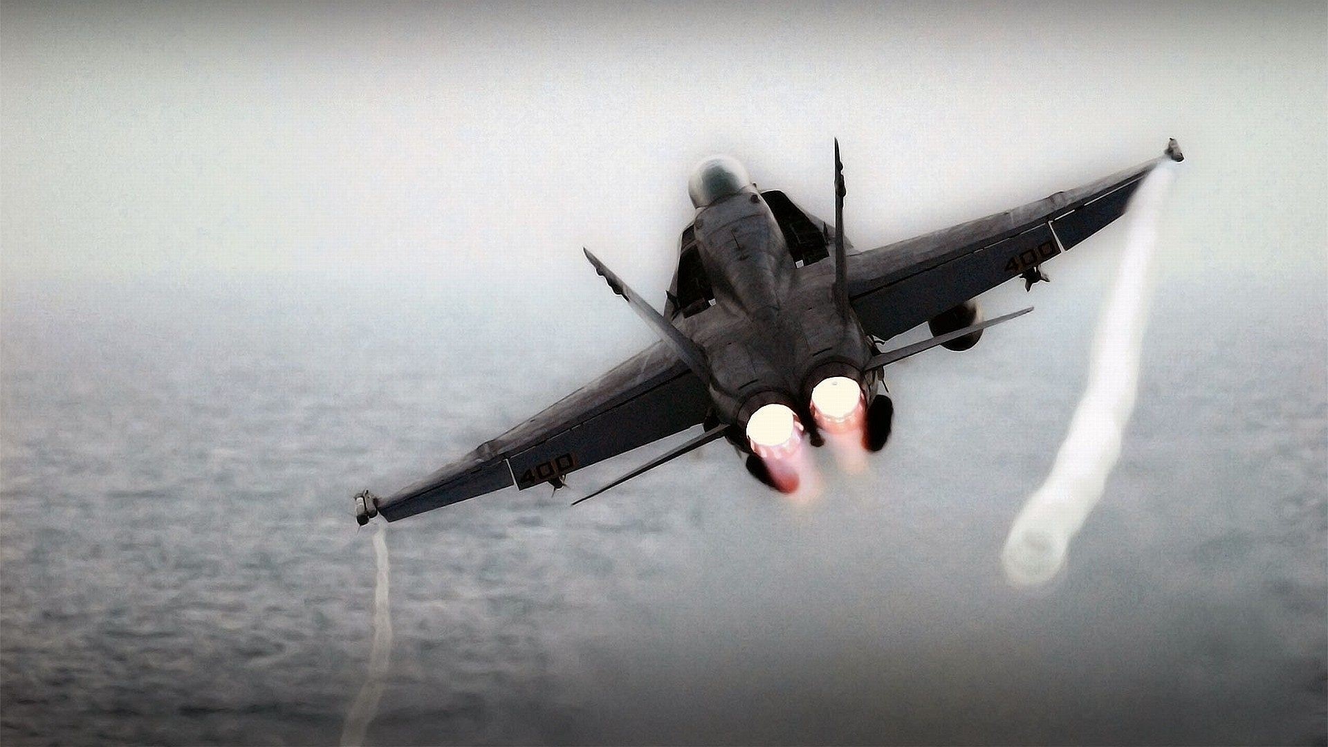 Fighter jet with afterburners over water HD Wallpaper