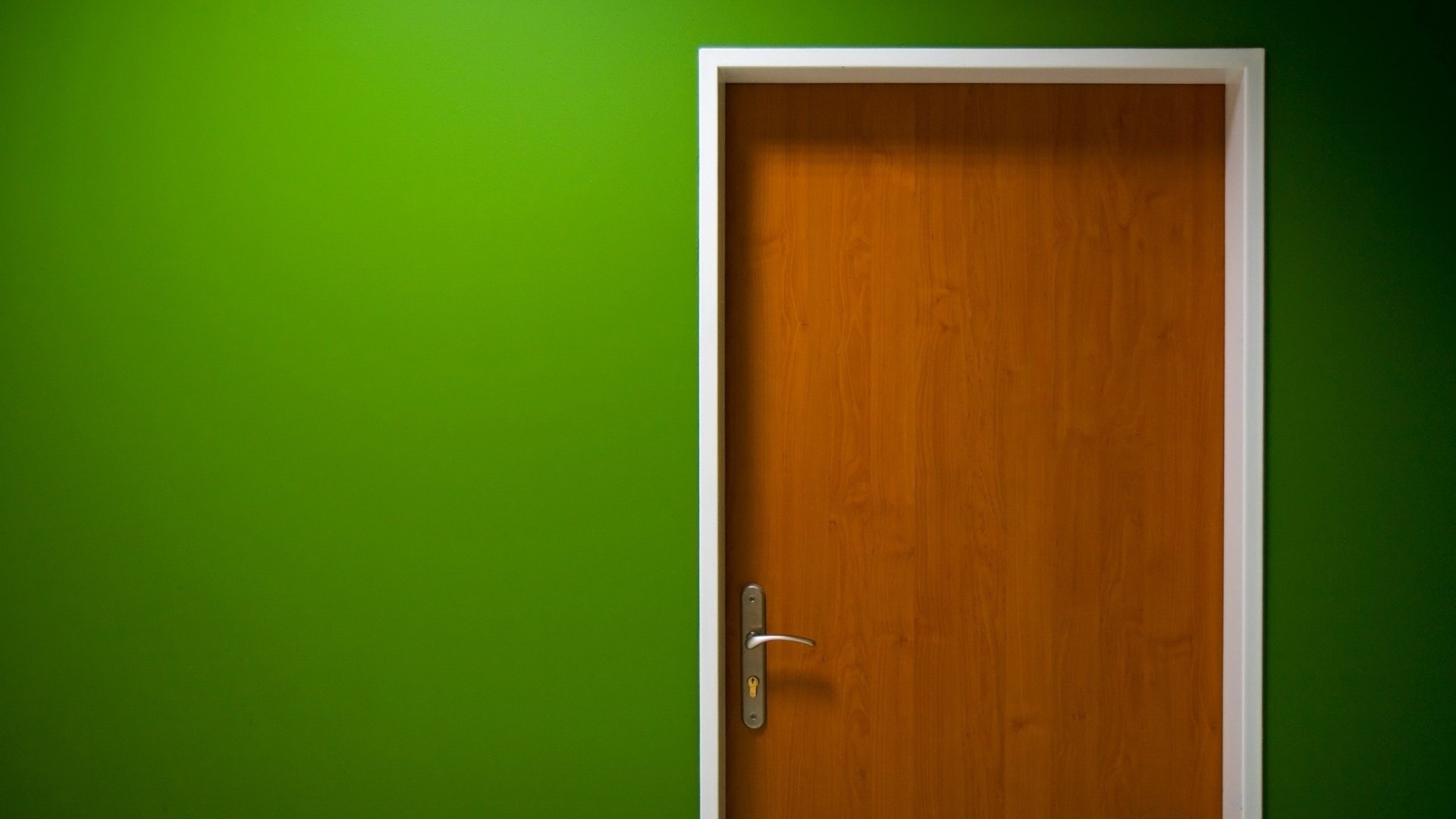 Wooden door with silver handle on green wall HD Wallpaper