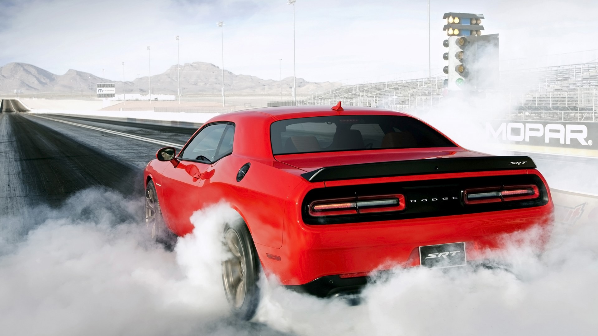 Red Dodge Challenger SRT doing a burnout on a drag strip HD Wallpaper