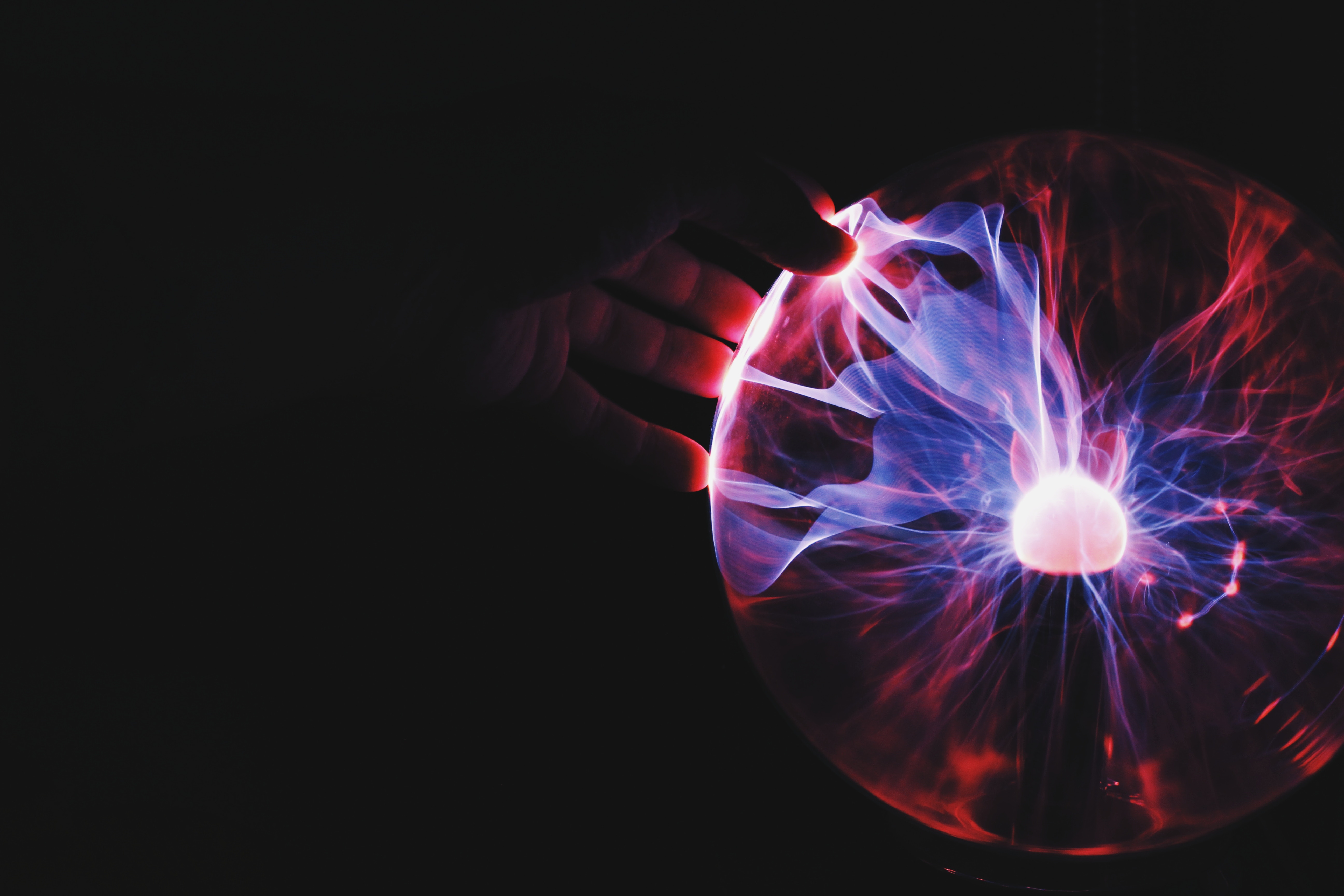 Hand touching a plasma lamp with colorful light HD Wallpaper