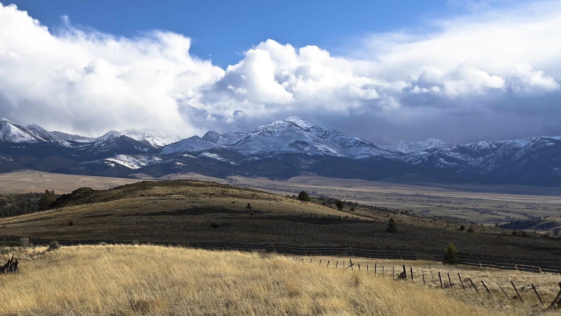 Snowy Mountains Overlooking a Field HD Wallpaper