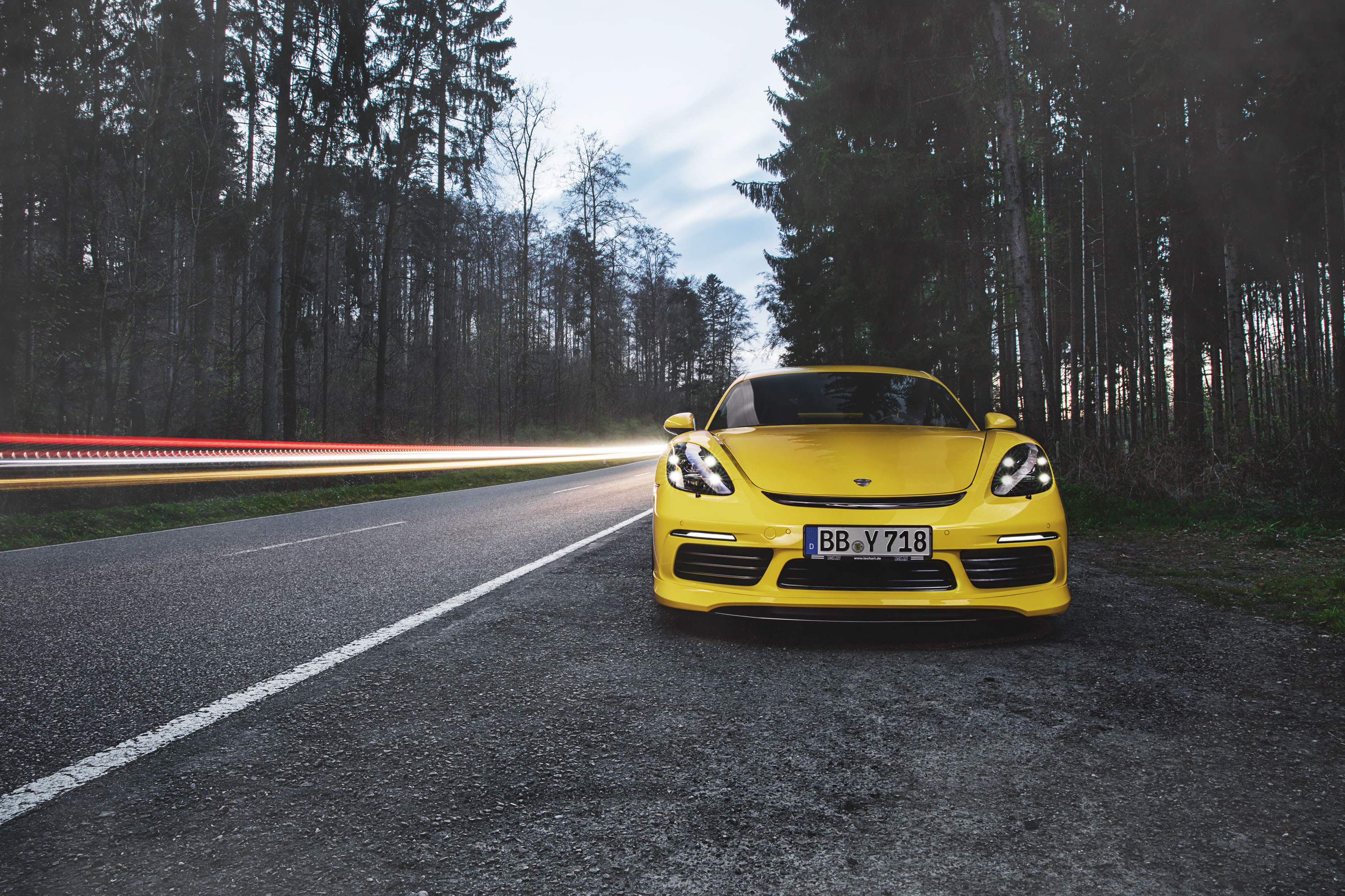 Yellow 2017 Porsche 718 Cayman on a Forest Road HD Wallpaper