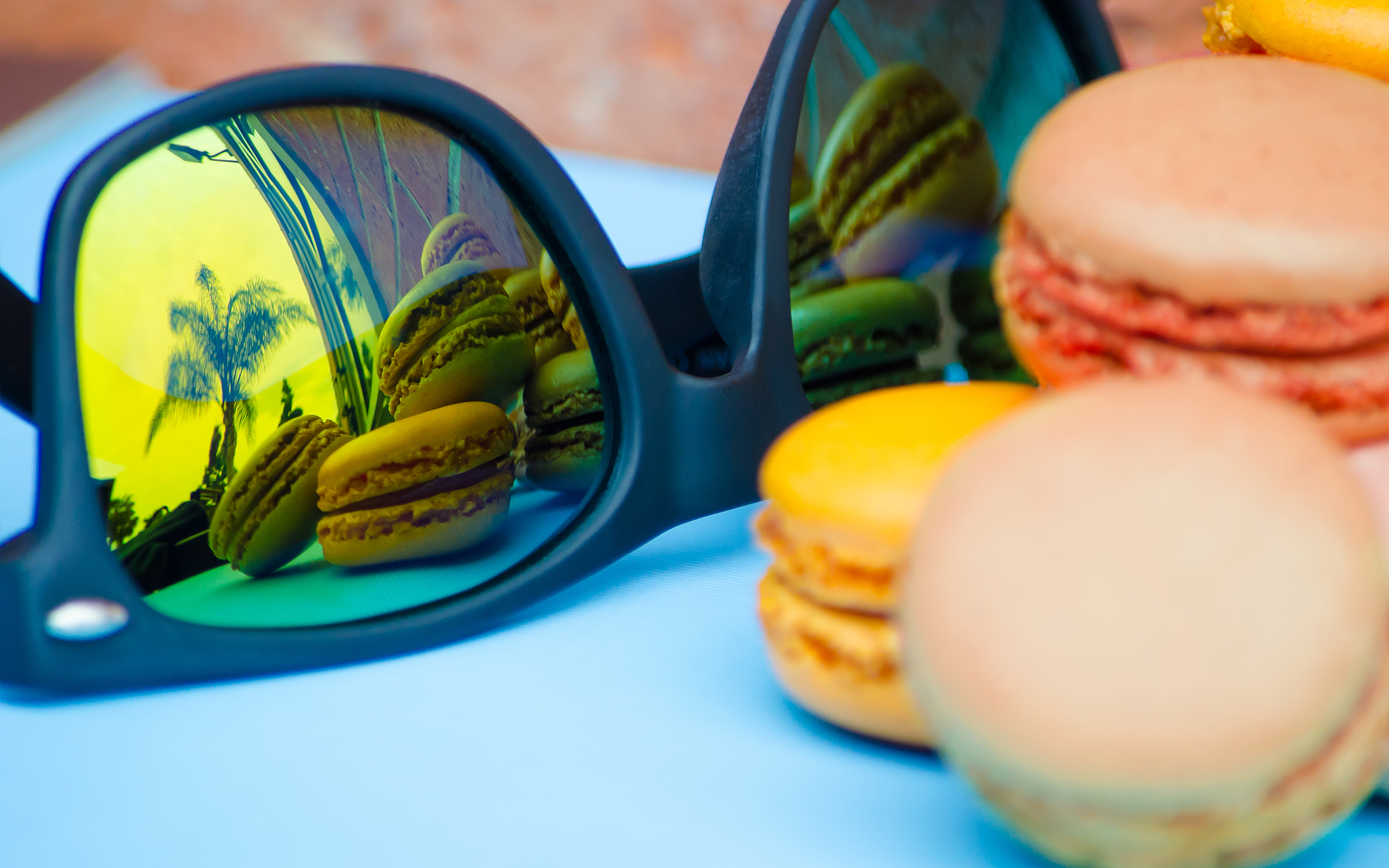 Sunglasses reflecting French Macarons and palm trees HD Wallpaper