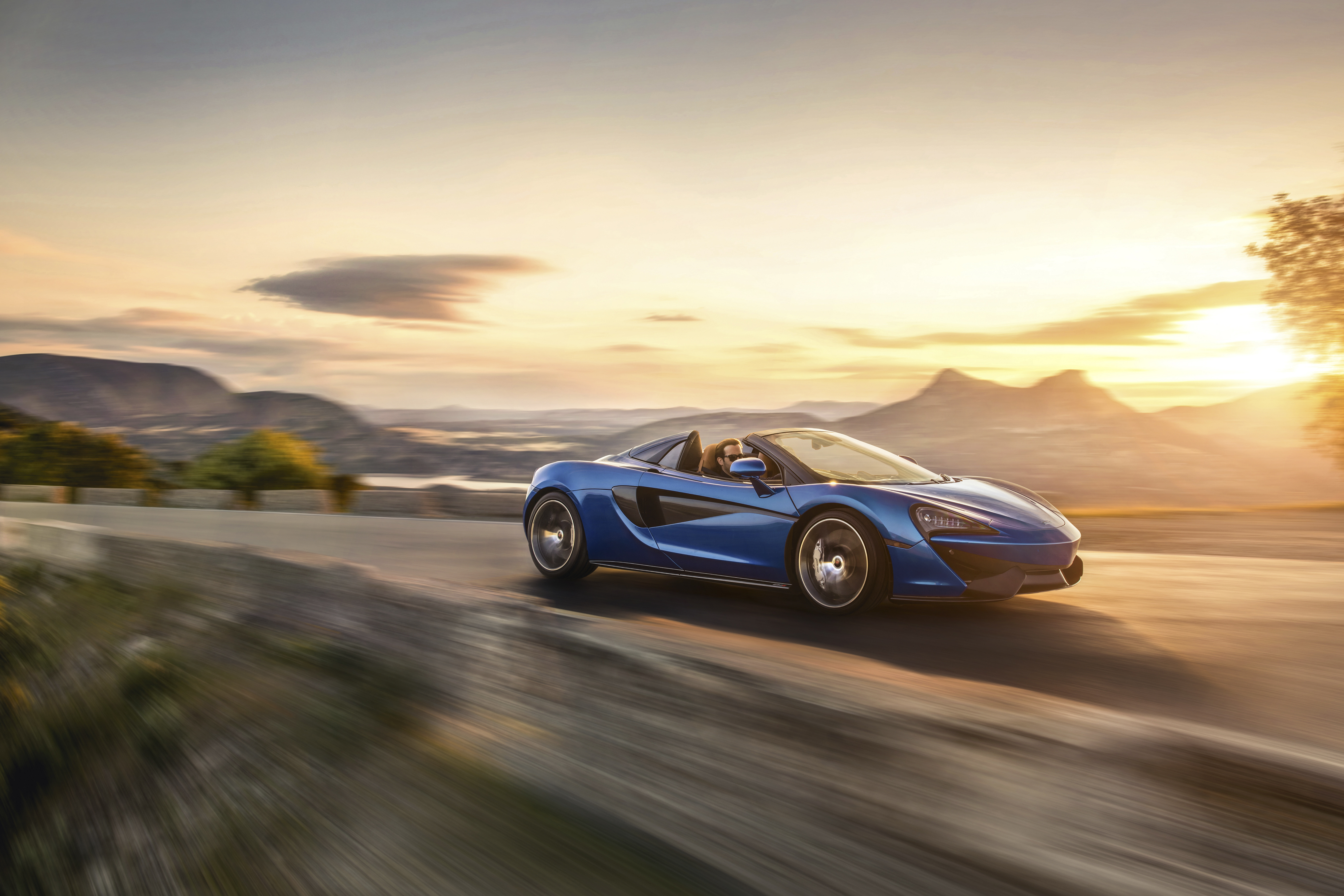 Blue McLaren 570S Spider driving at sunset HD Wallpaper