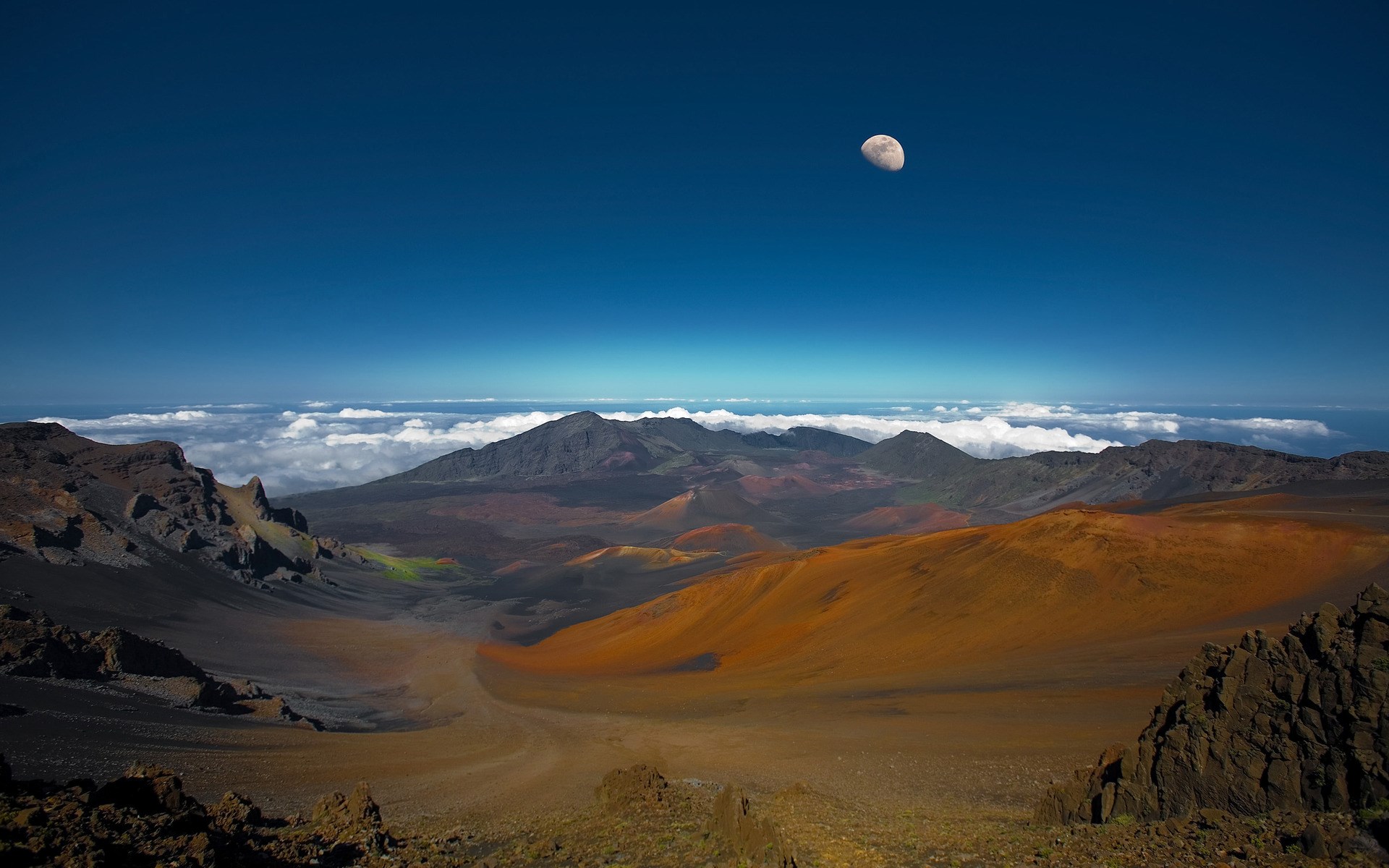 Volcanic landscape with moon in blue sky HD Wallpaper