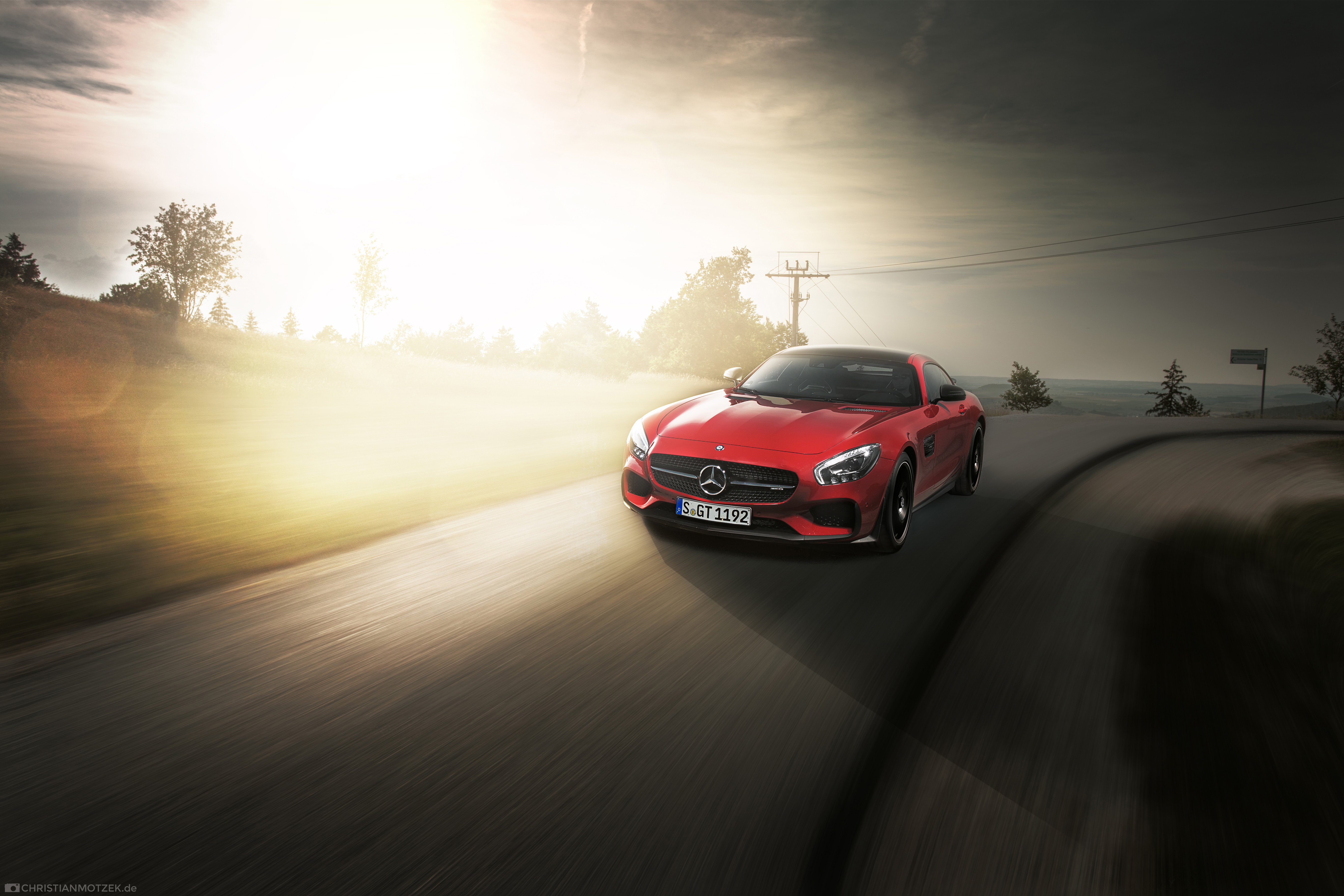 Red Mercedes-AMG GTS driving on a winding road HD Wallpaper