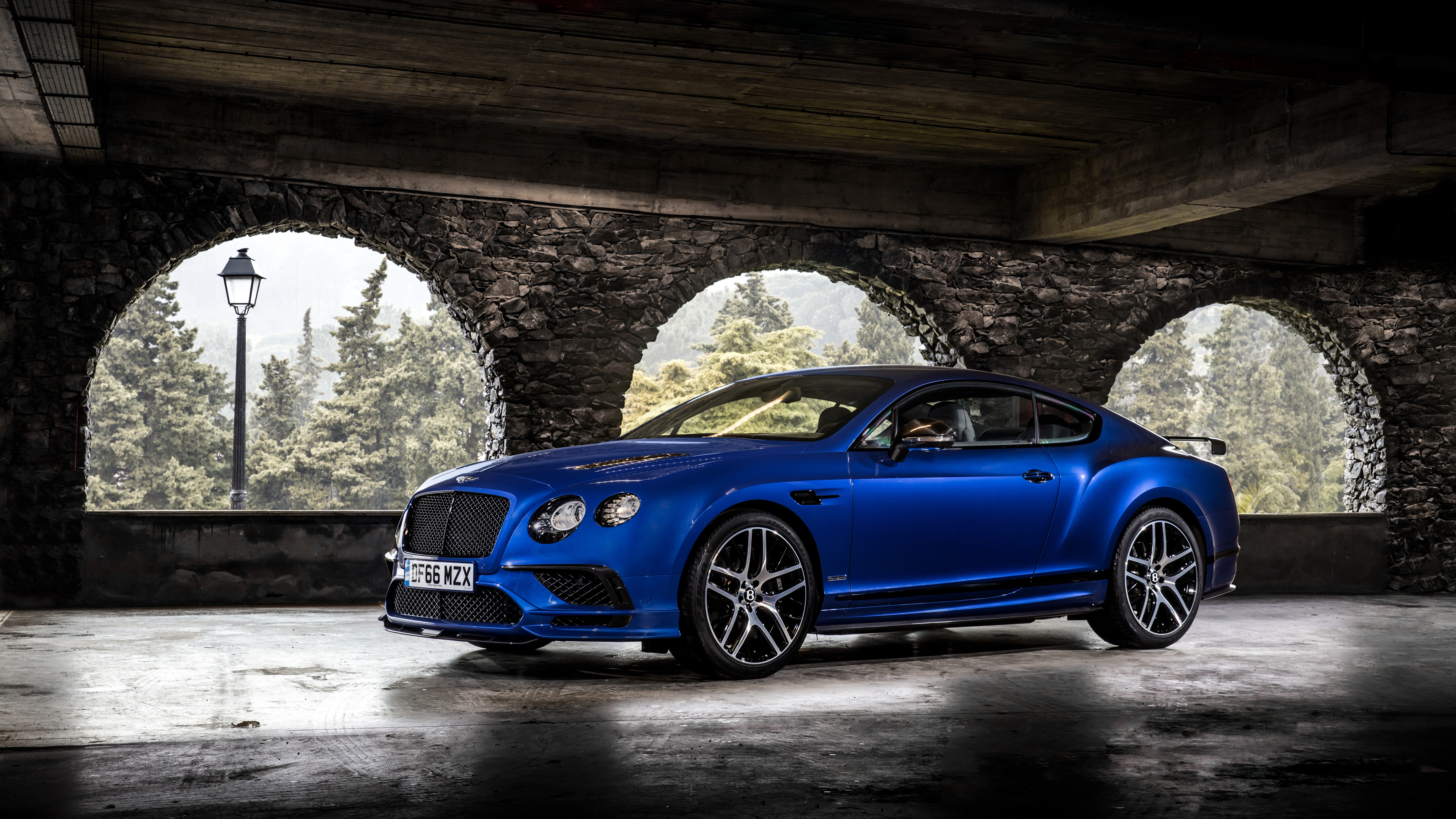 Blue Bentley Continental Supersports parked under stone arches HD Wallpaper