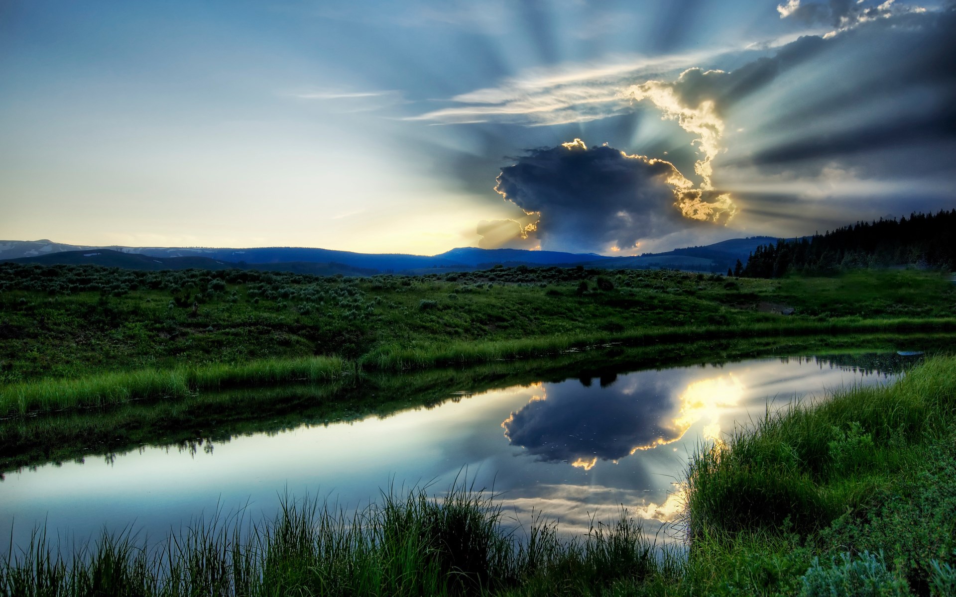 Sunbeams through clouds over a reflective river and grassy hills HD Wallpaper