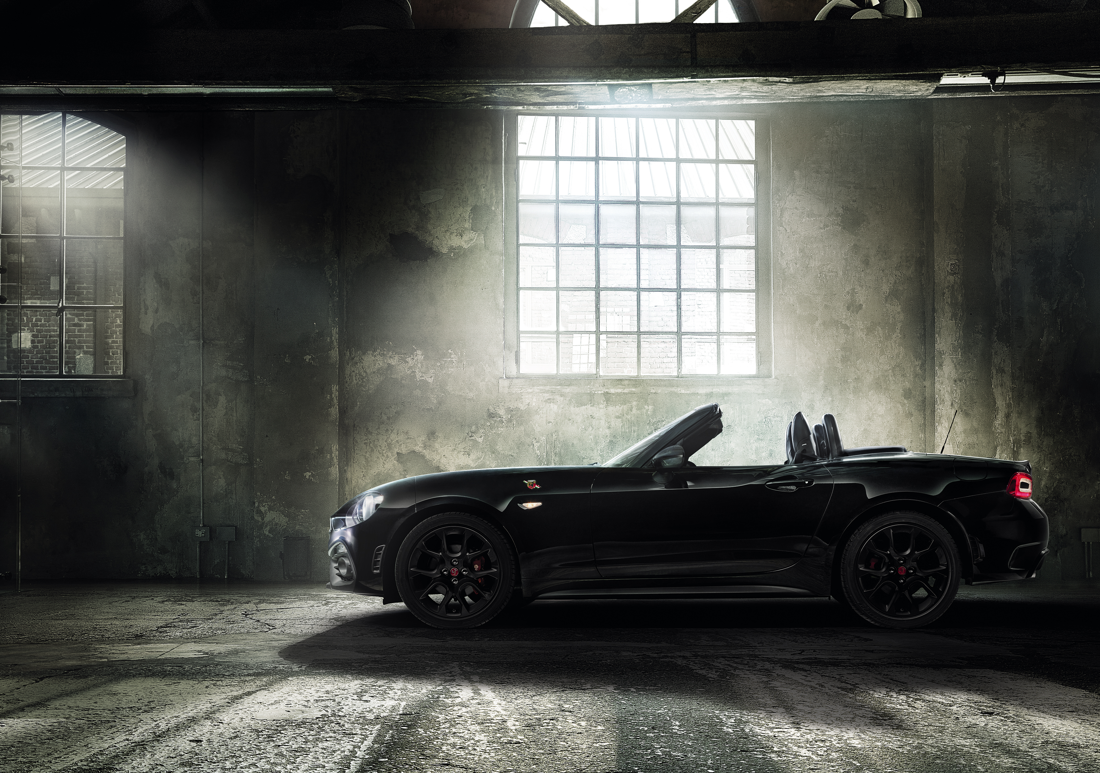 Black Abarth 124 Spider Scorpione convertible in a warehouse HD Wallpaper