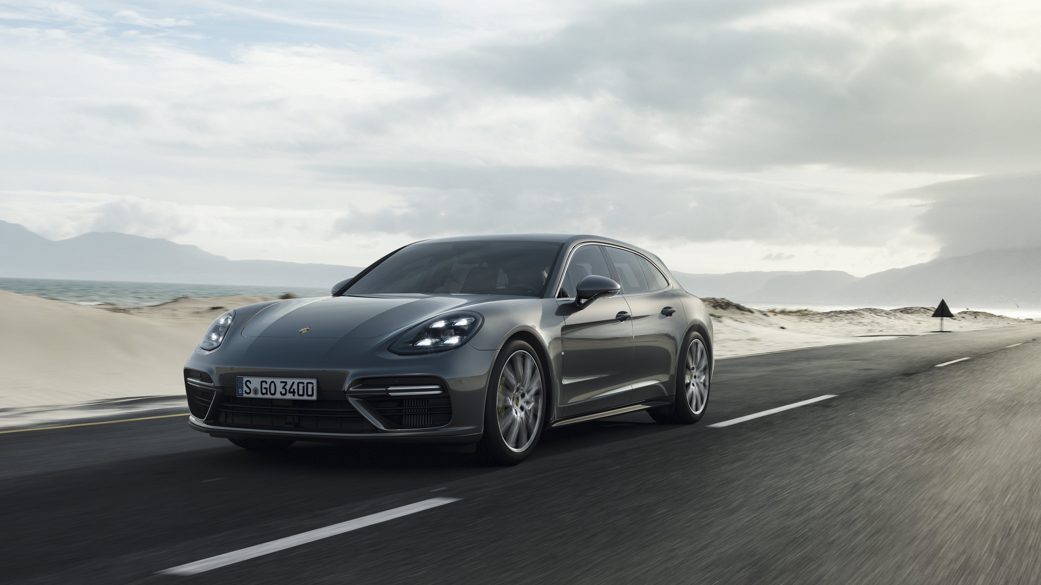 Porsche Panamera Turbo Sport Turismo driving on a coastal road HD Wallpaper