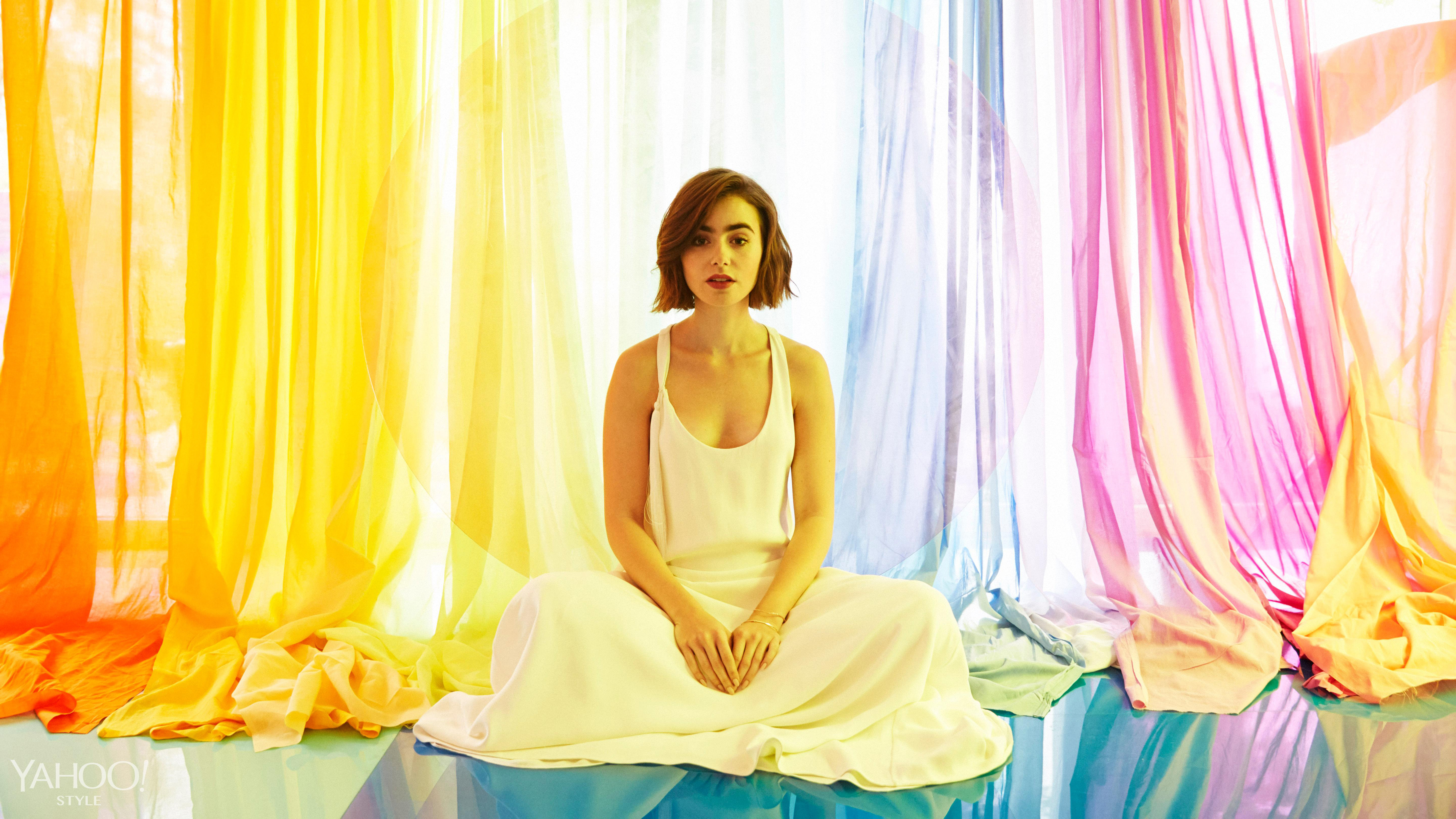Lily Collins sitting in front of rainbow curtains HD Wallpaper