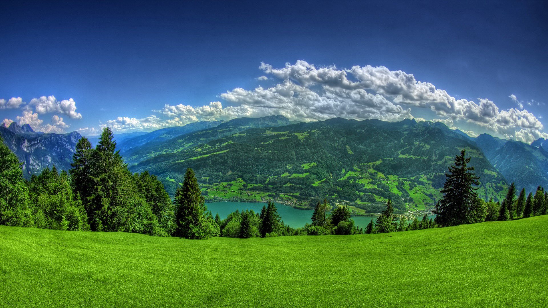 Panoramic view of a green mountain valley with a lake HD Wallpaper
