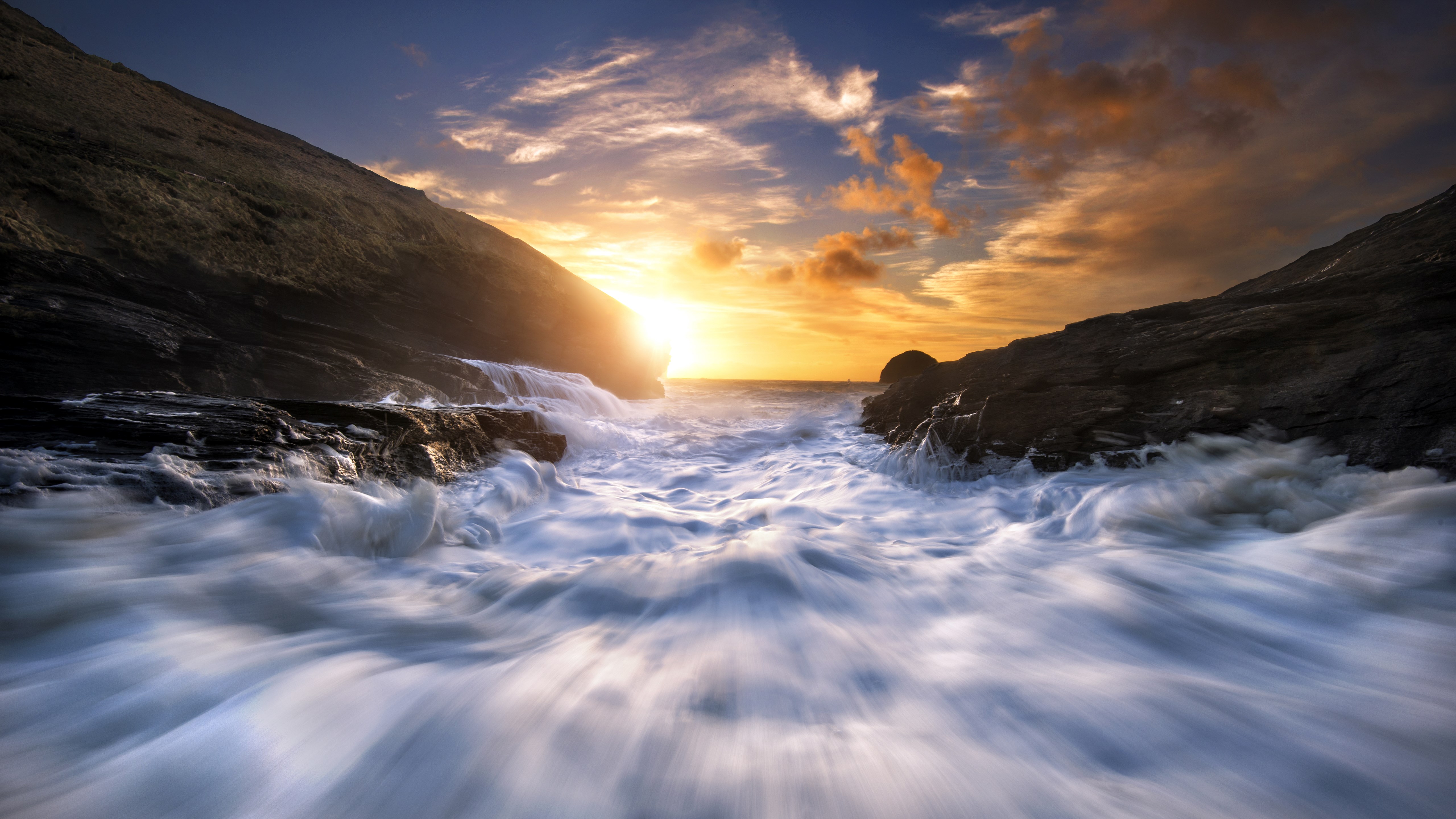 Ocean waves crashing against rocks at sunset HD Wallpaper