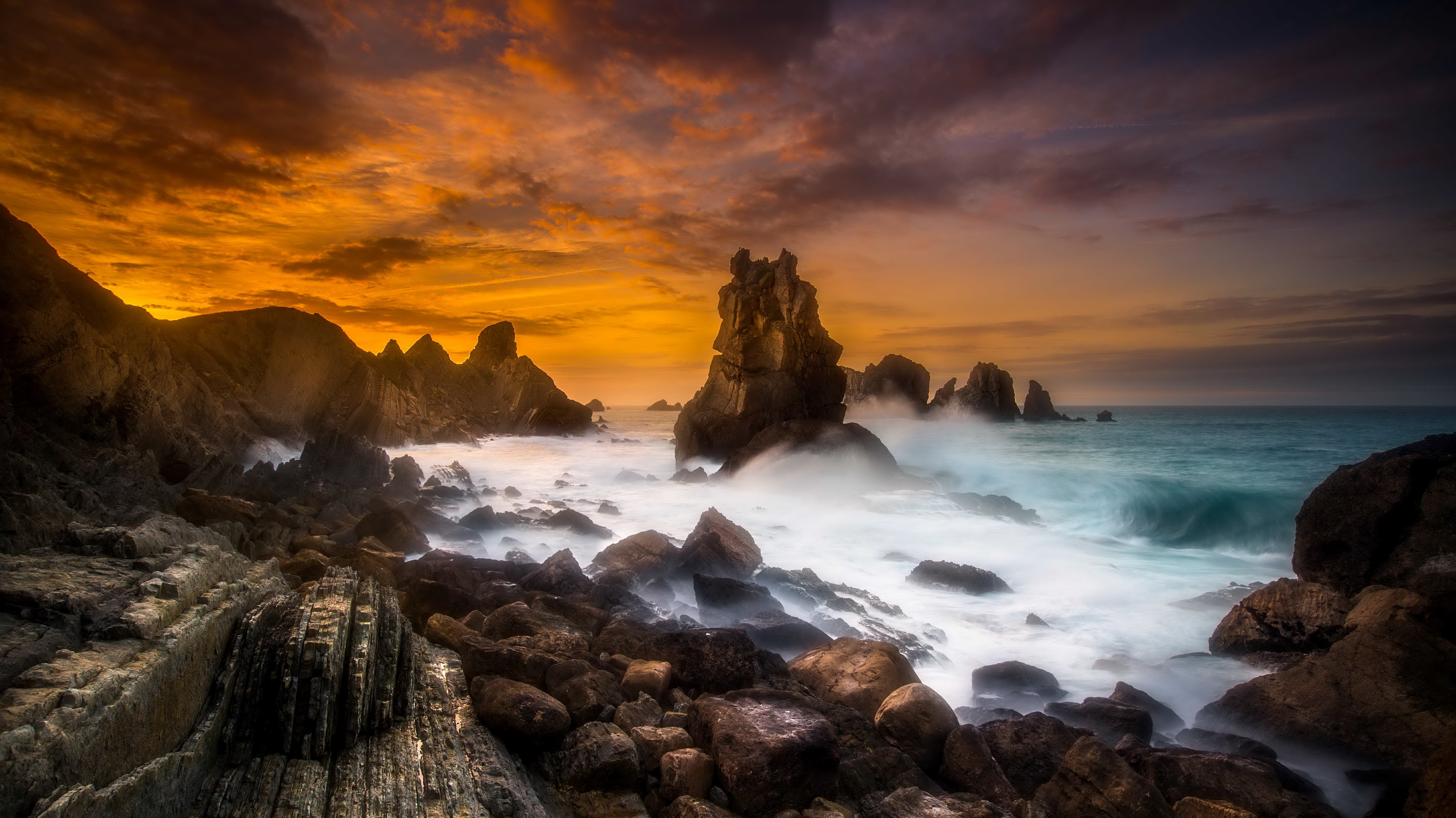 Rocky coastline with crashing waves at sunset HD Wallpaper