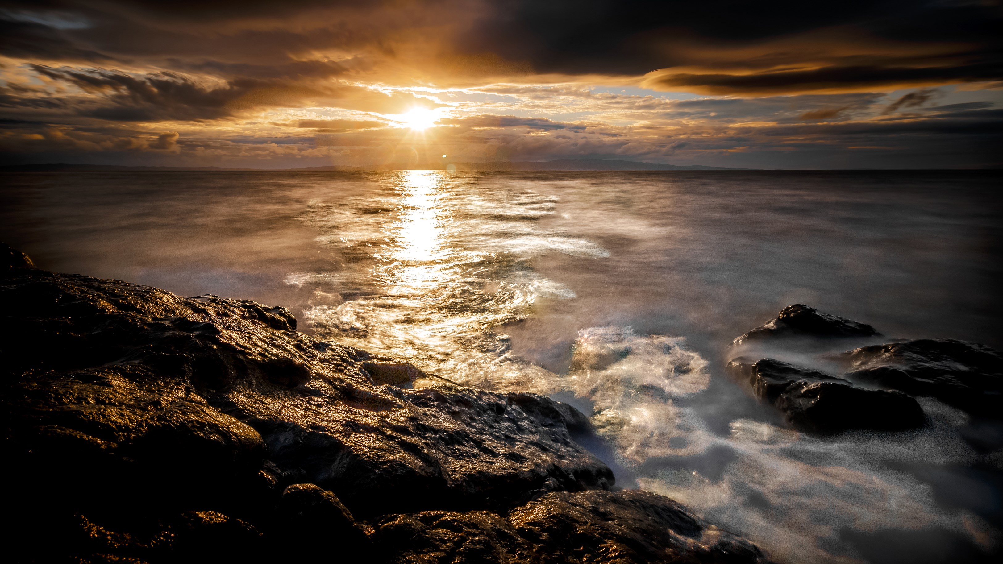 Sunset over the ocean with rocky shore HD Wallpaper