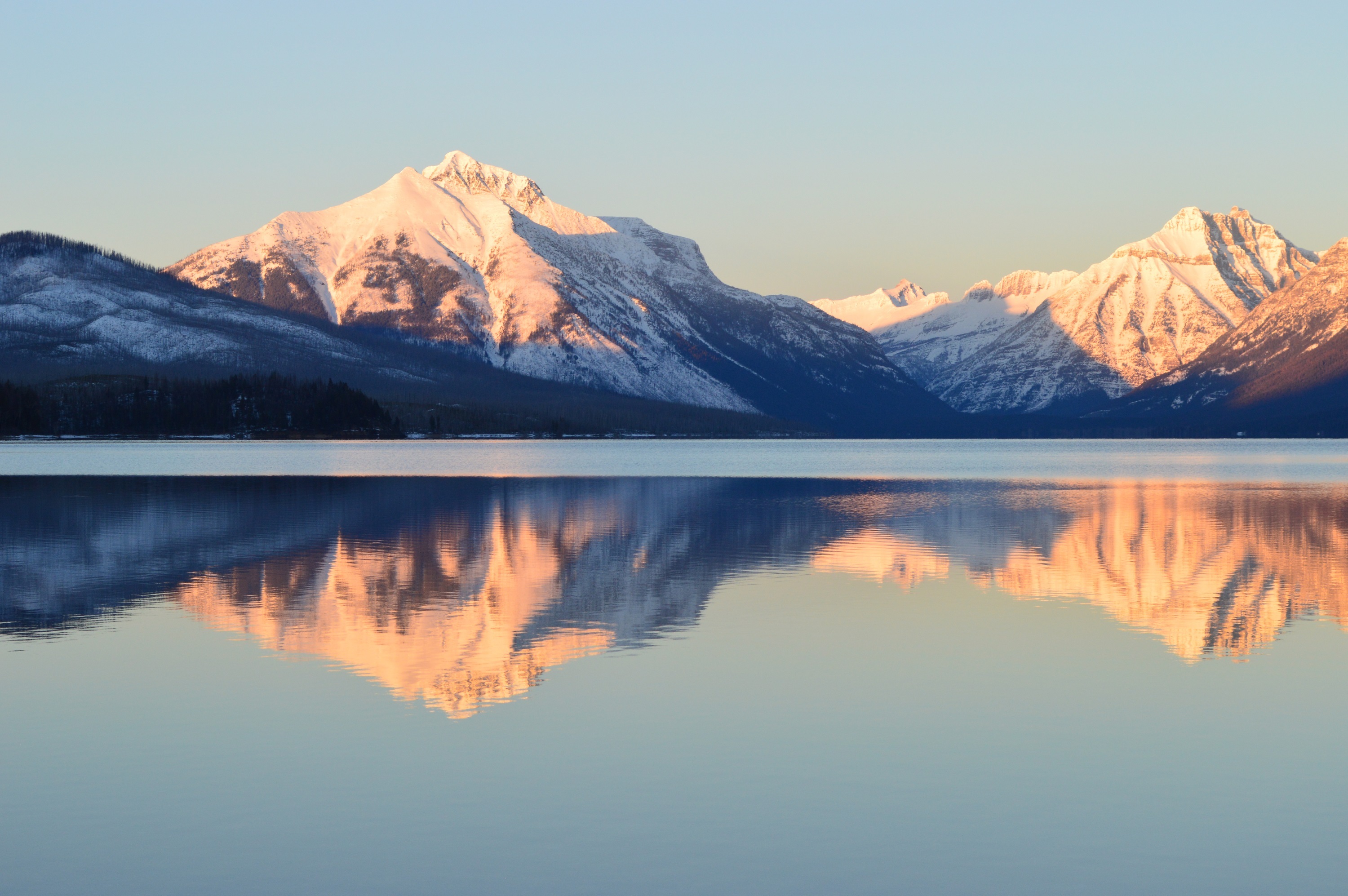 Snow-capped mountains reflected in Lake McDonald, Glacier National Park HD Wallpaper