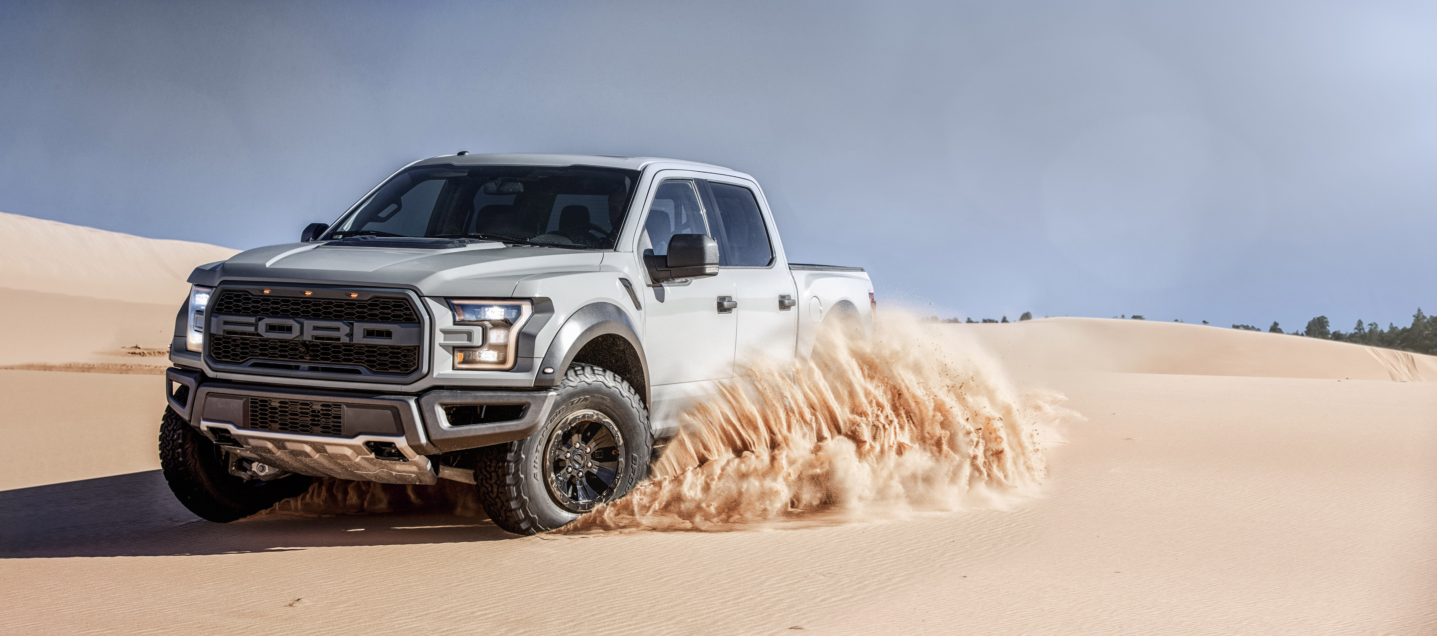 2017 Ford F-150 Raptor driving on sand dunes HD Wallpaper