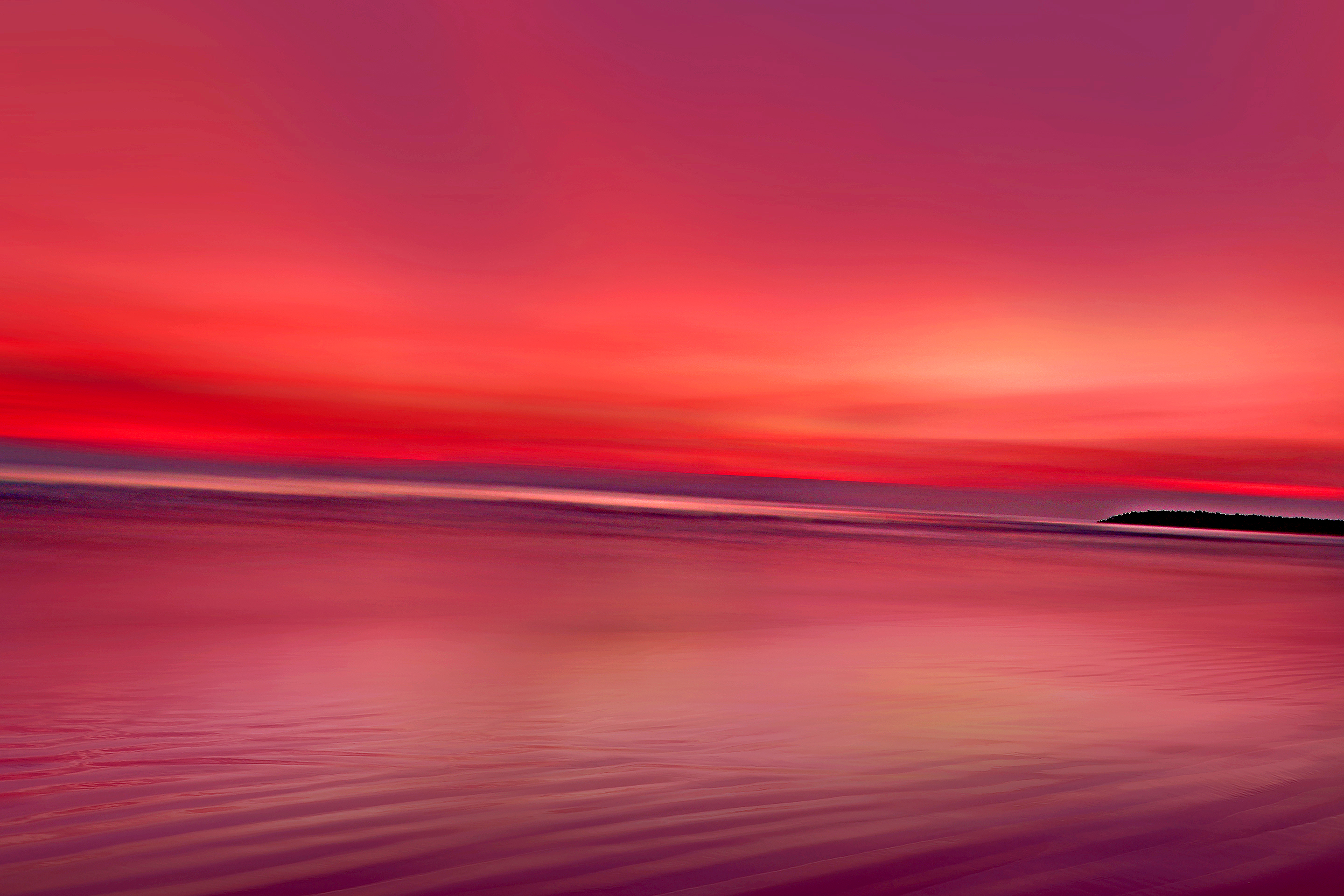 Crimson sunset over a calm ocean with a distant island HD Wallpaper