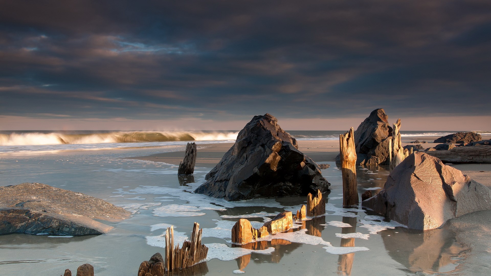 Beach with rocks and ocean waves at sunset HD Wallpaper