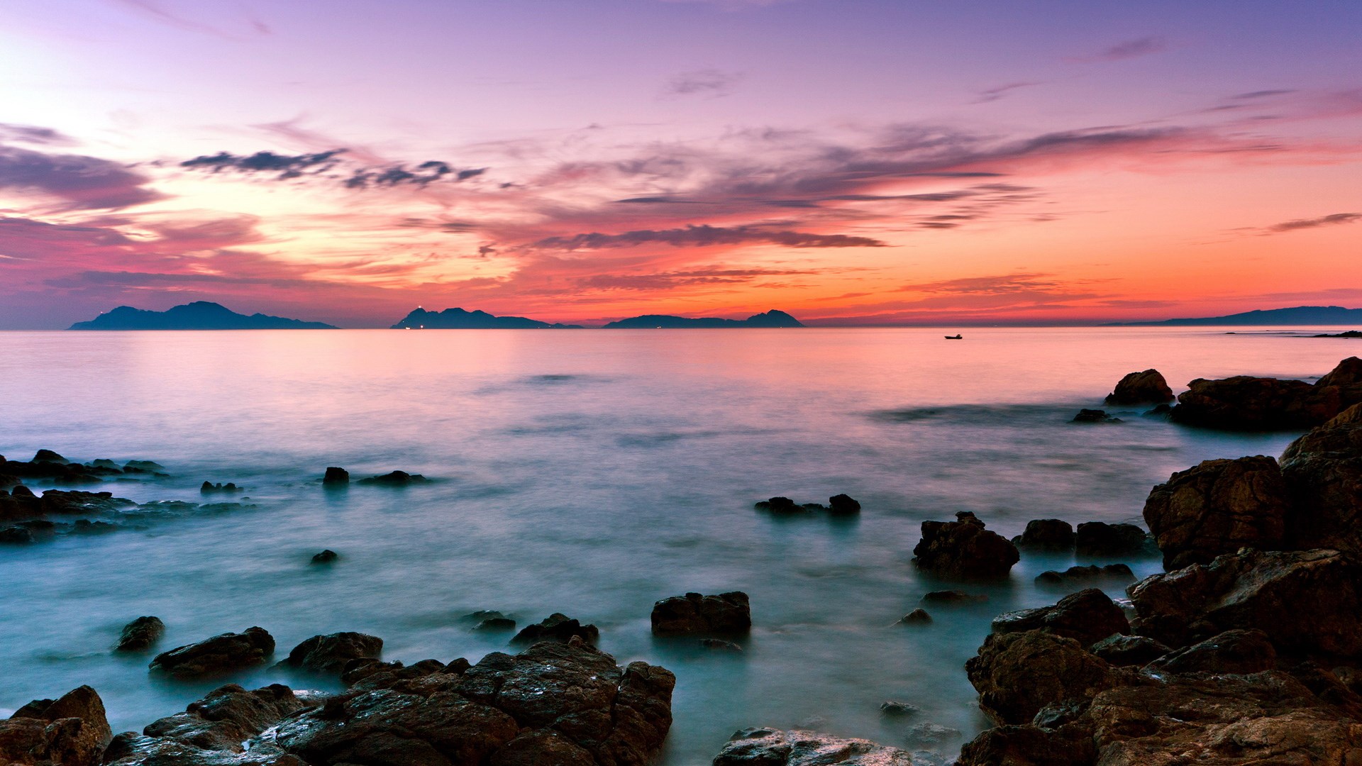 Sunset over the ocean with islands and rocks HD Wallpaper