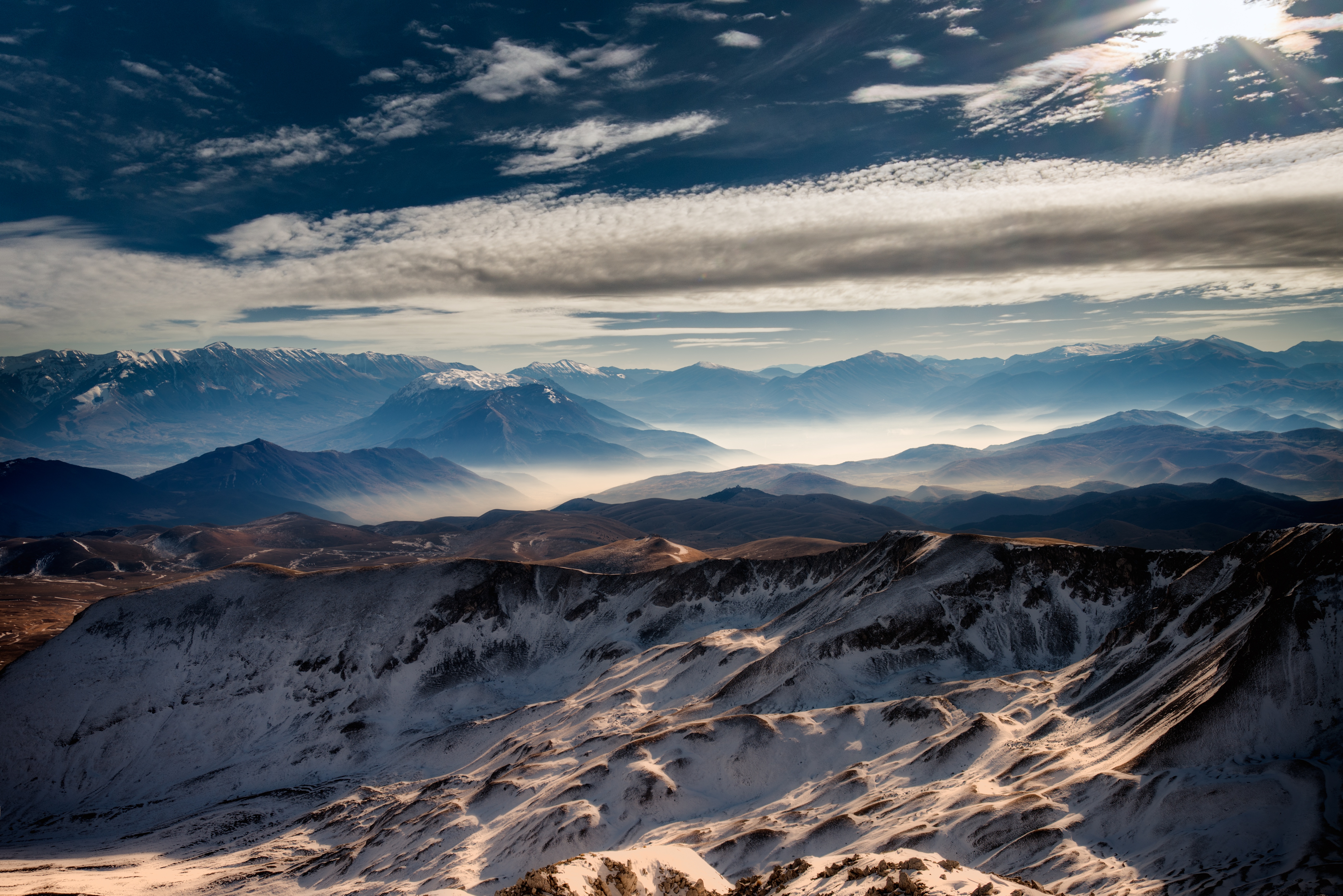 Snow-capped mountains under a sunny sky HD Wallpaper