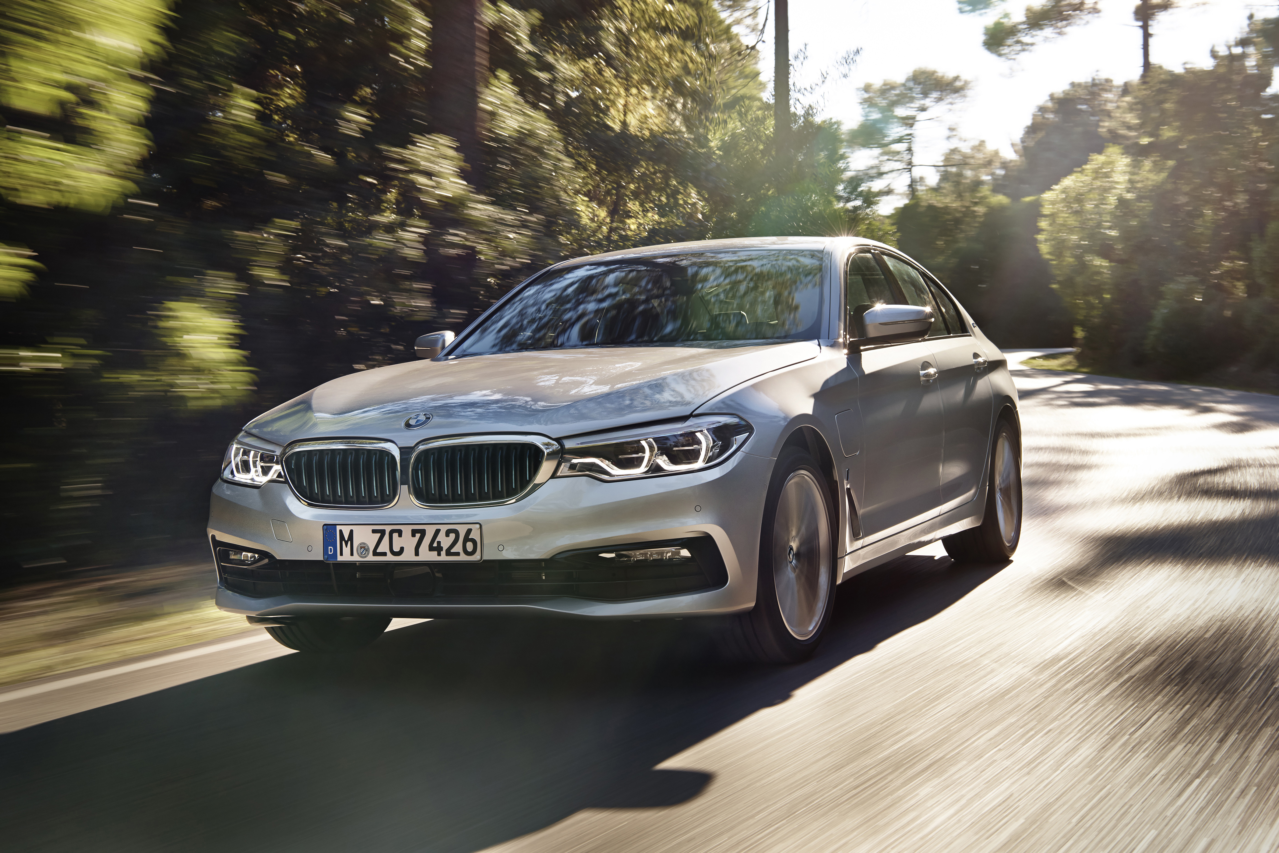 2018 BMW 530e iPerformance driving on a road HD Wallpaper