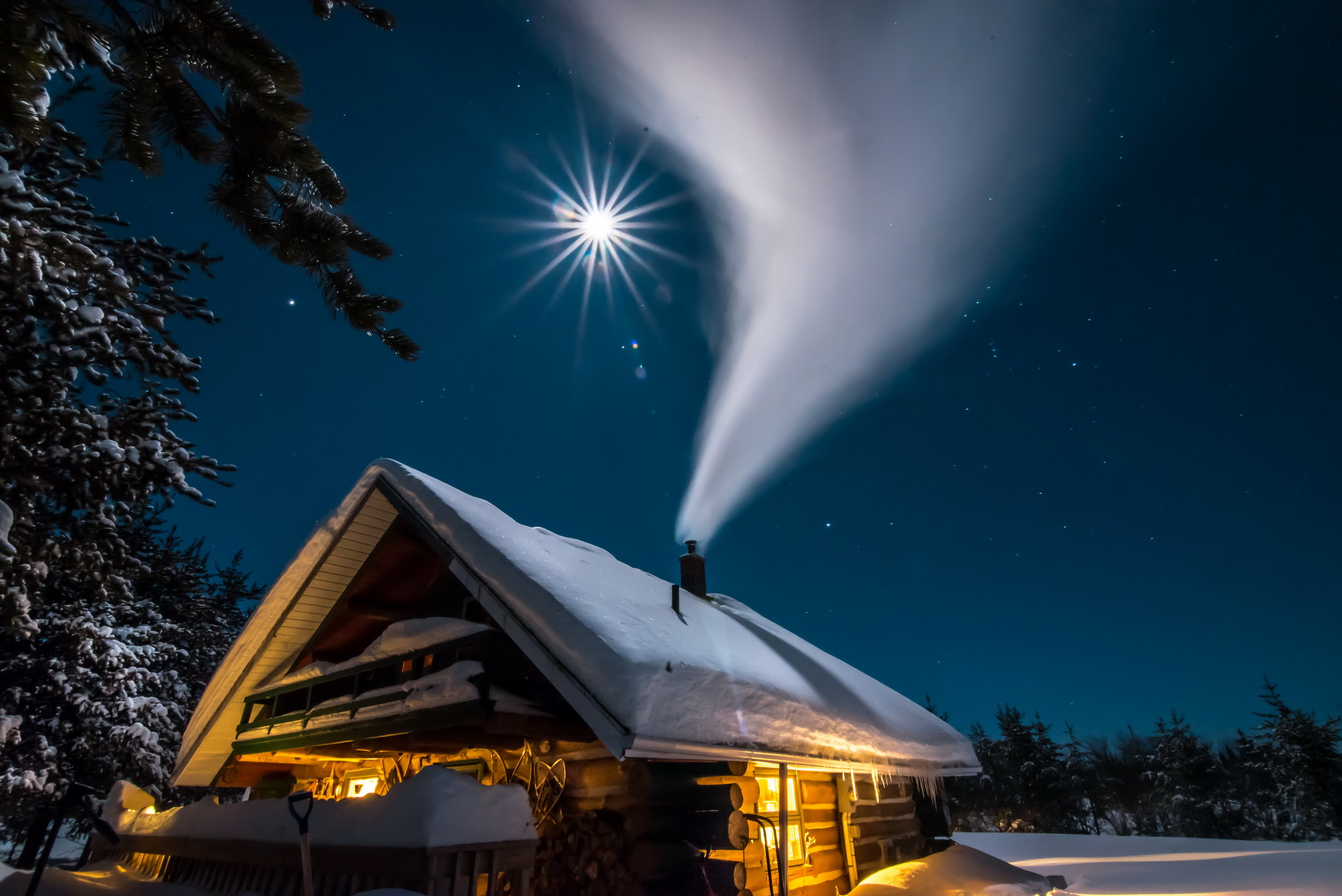 Log cabin with smoke rising under the moon at night HD Wallpaper