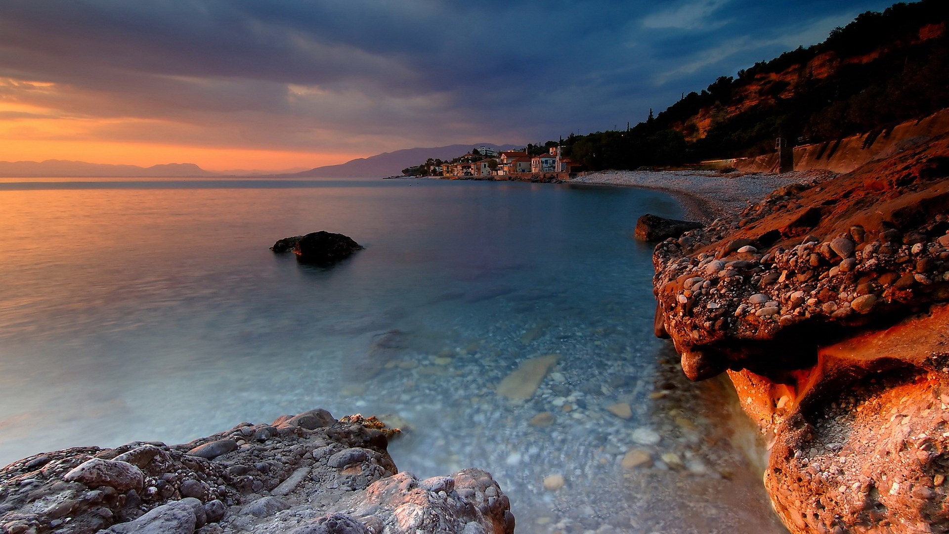 Coastal village at sunset with rocky shore HD Wallpaper