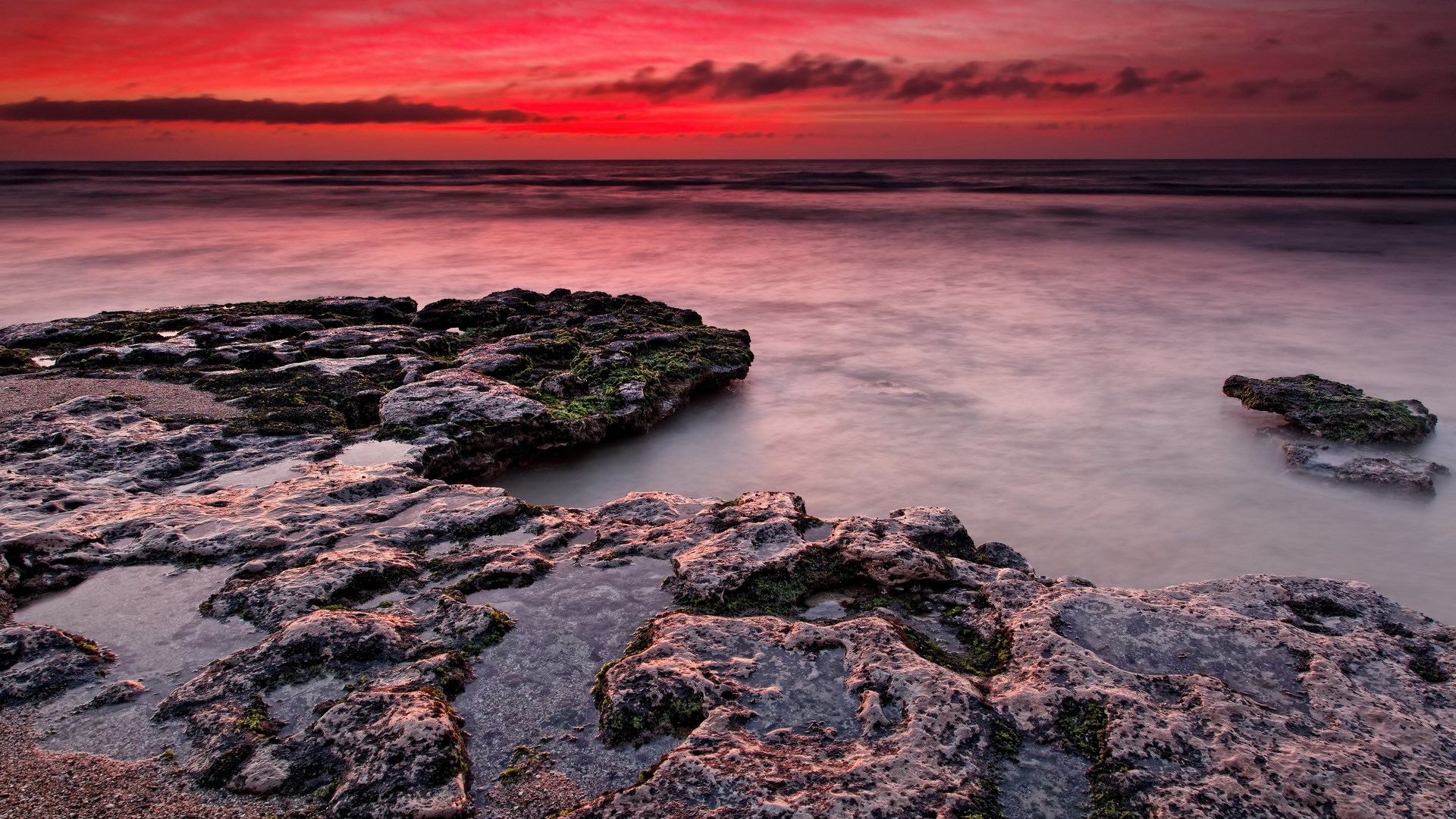 Sunset over rocky coastline with calm ocean HD Wallpaper
