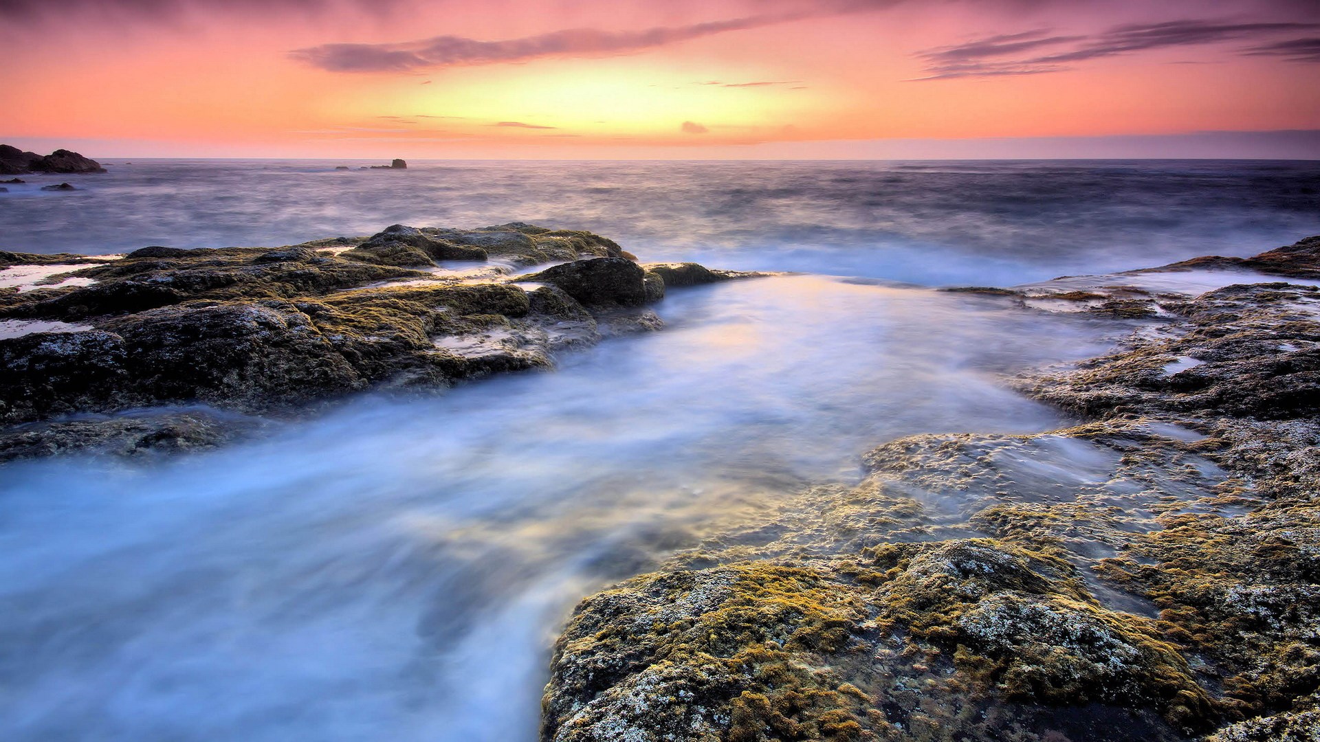 Ocean waves crashing on rocky shore at sunset HD Wallpaper