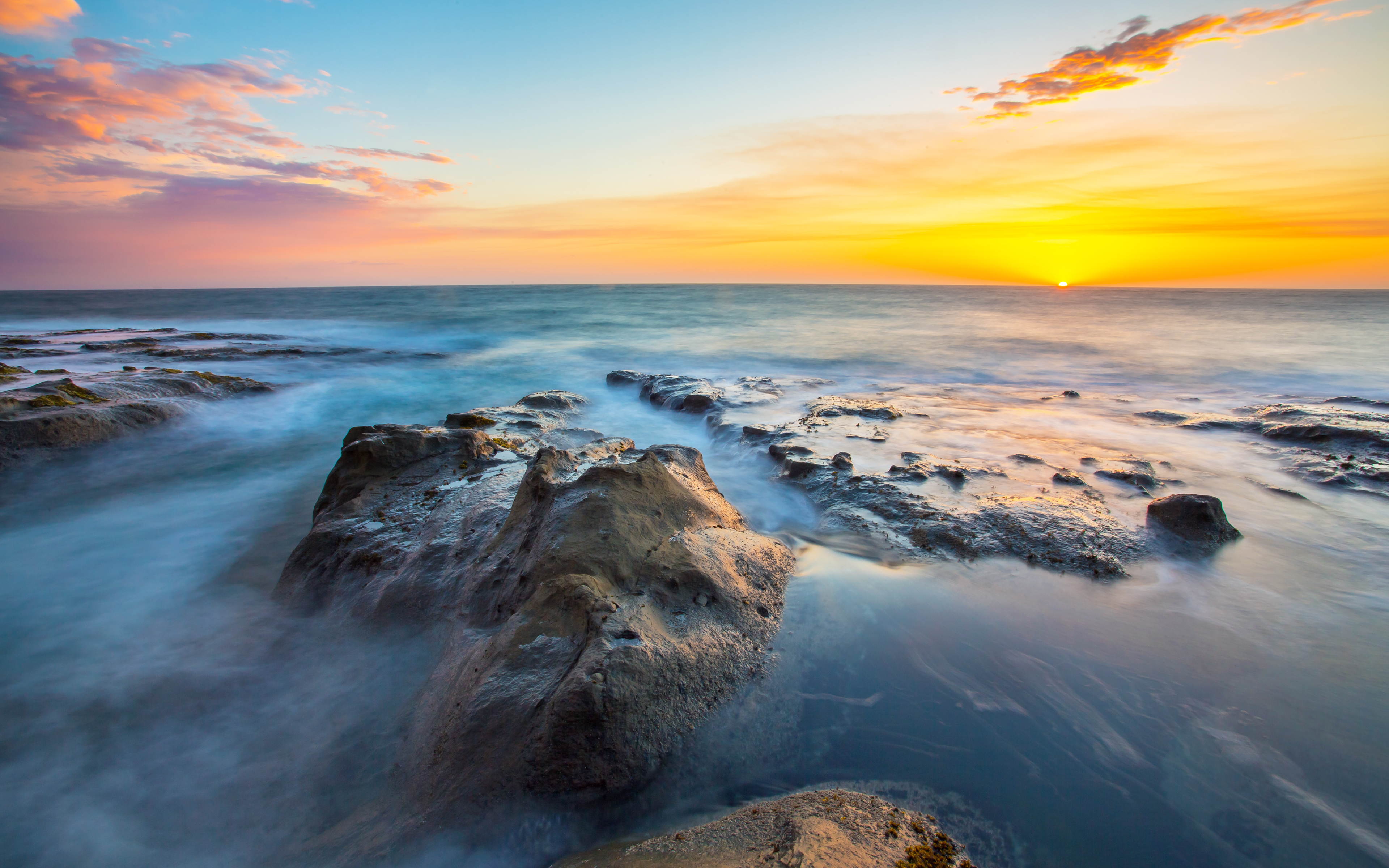 Sunset over rocky coast with ocean waves HD Wallpaper